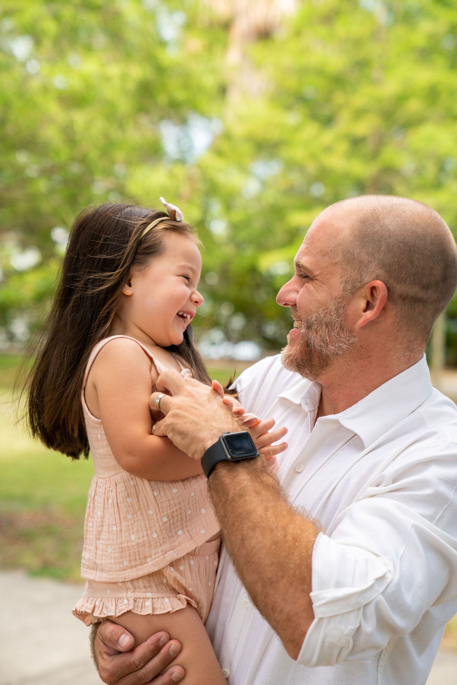A joyful moment captured between a parent and child playing together outdoors on a sunny day.