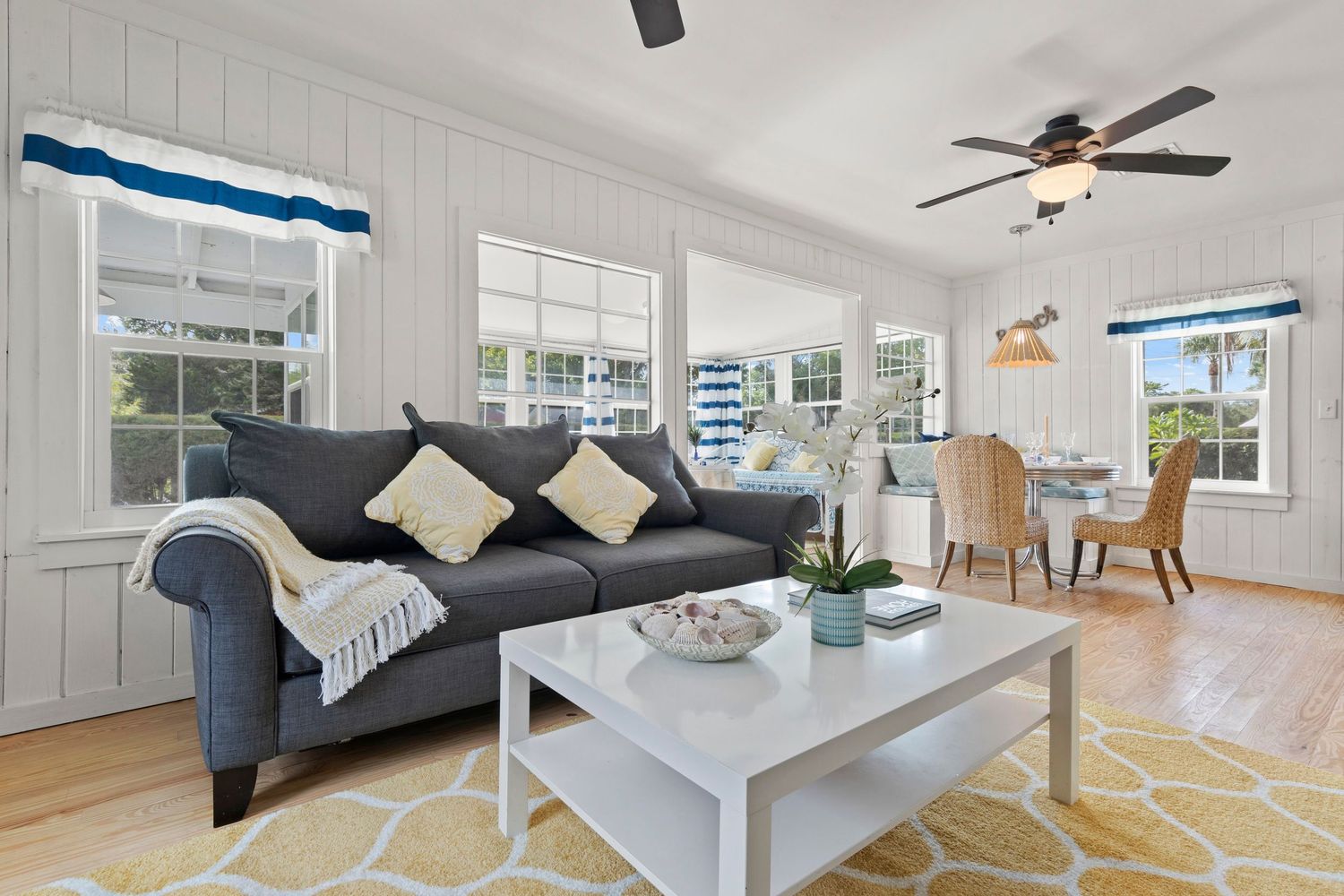 Bright open concept living area with white walls, hardwood floors and contemporary furniture.