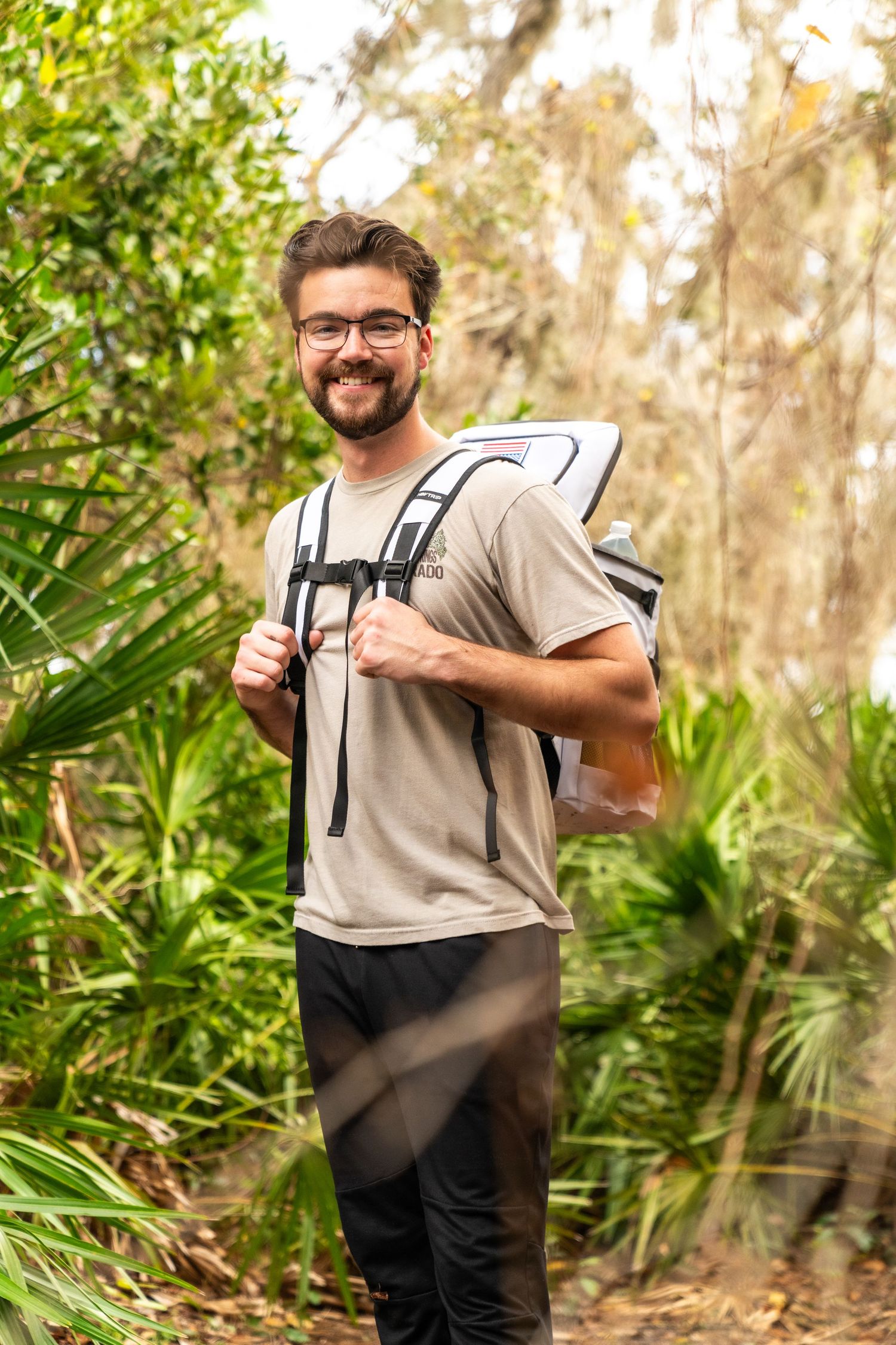 Outdoor camping gear and equipment displayed in natural setting with foliage background.