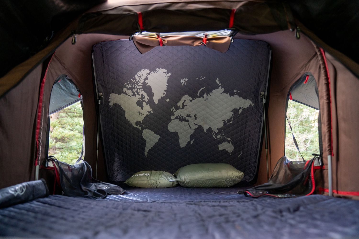 World map design on dark fabric inside tent or vehicle with ambient lighting.