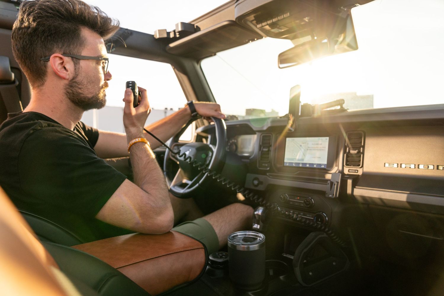 Interior view of vehicle dashboard with electronic displays during sunset.