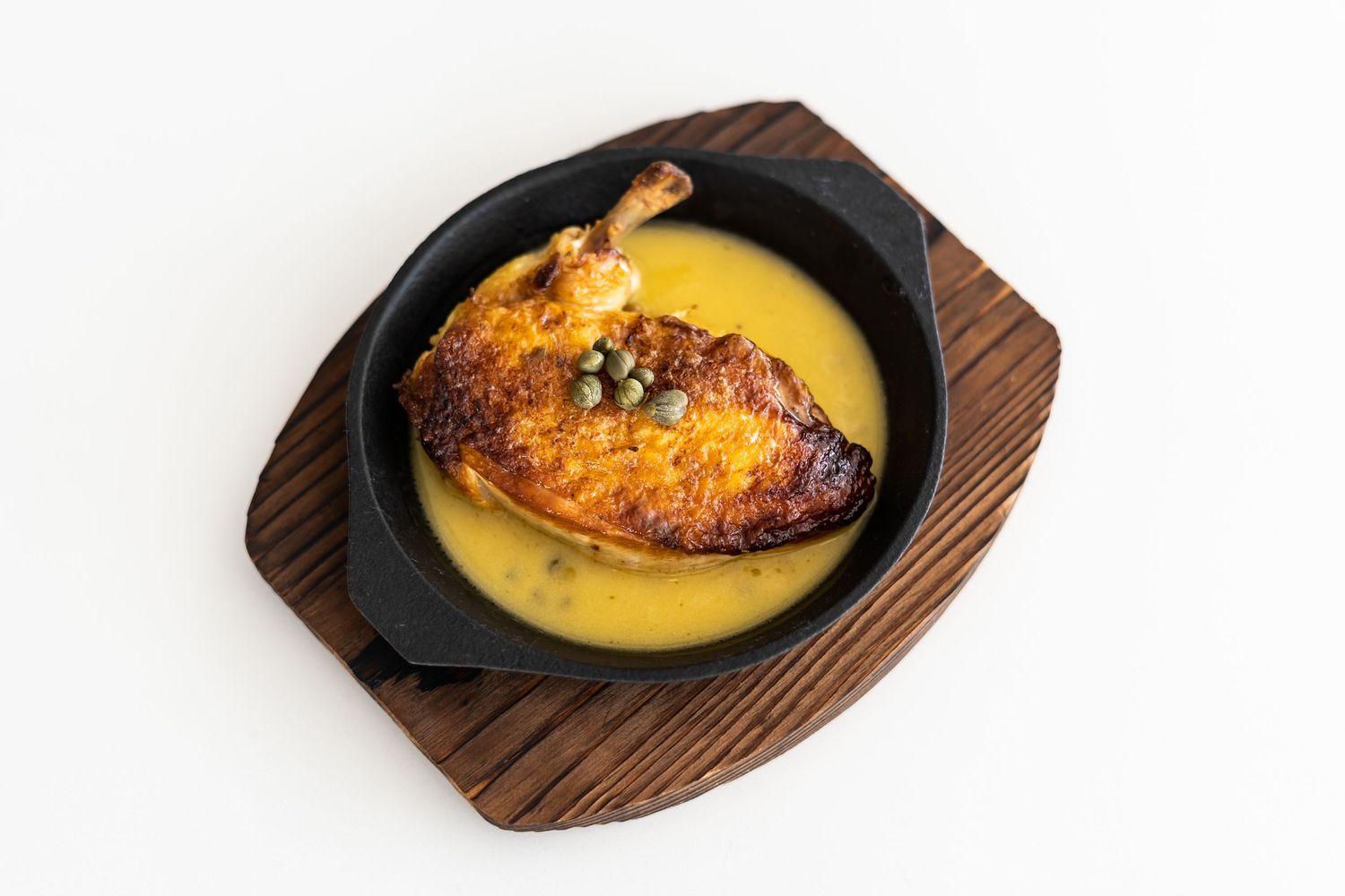 Three cast iron pans with golden brown baked desserts on wooden serving boards.