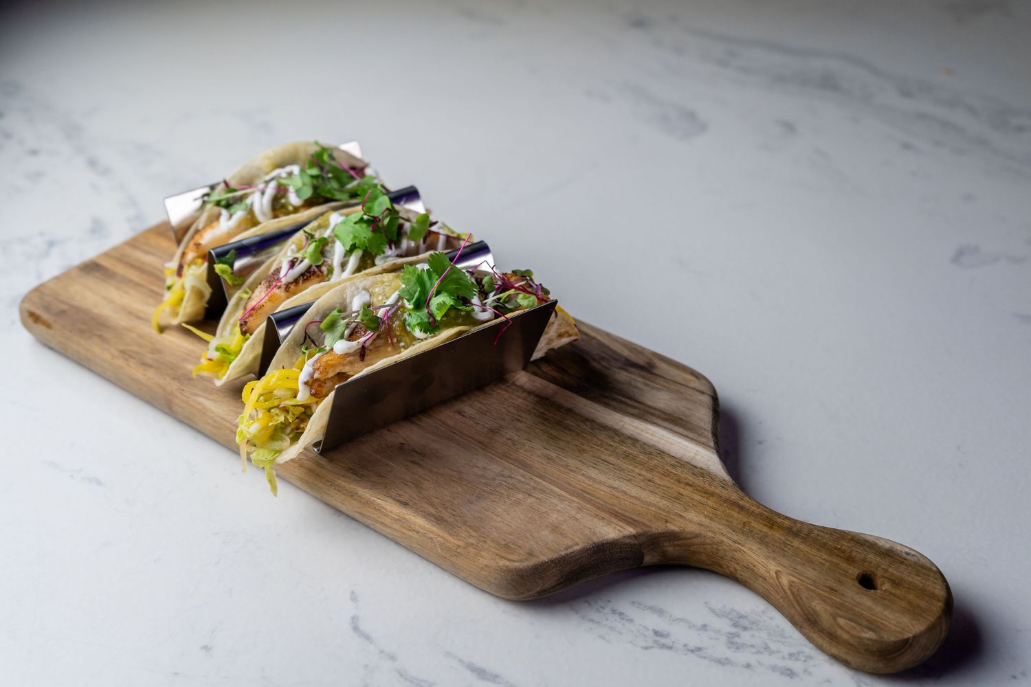 Five wooden serving boards display freshly made Vietnamese banh mi sandwiches with colorful vegetables and herbs.