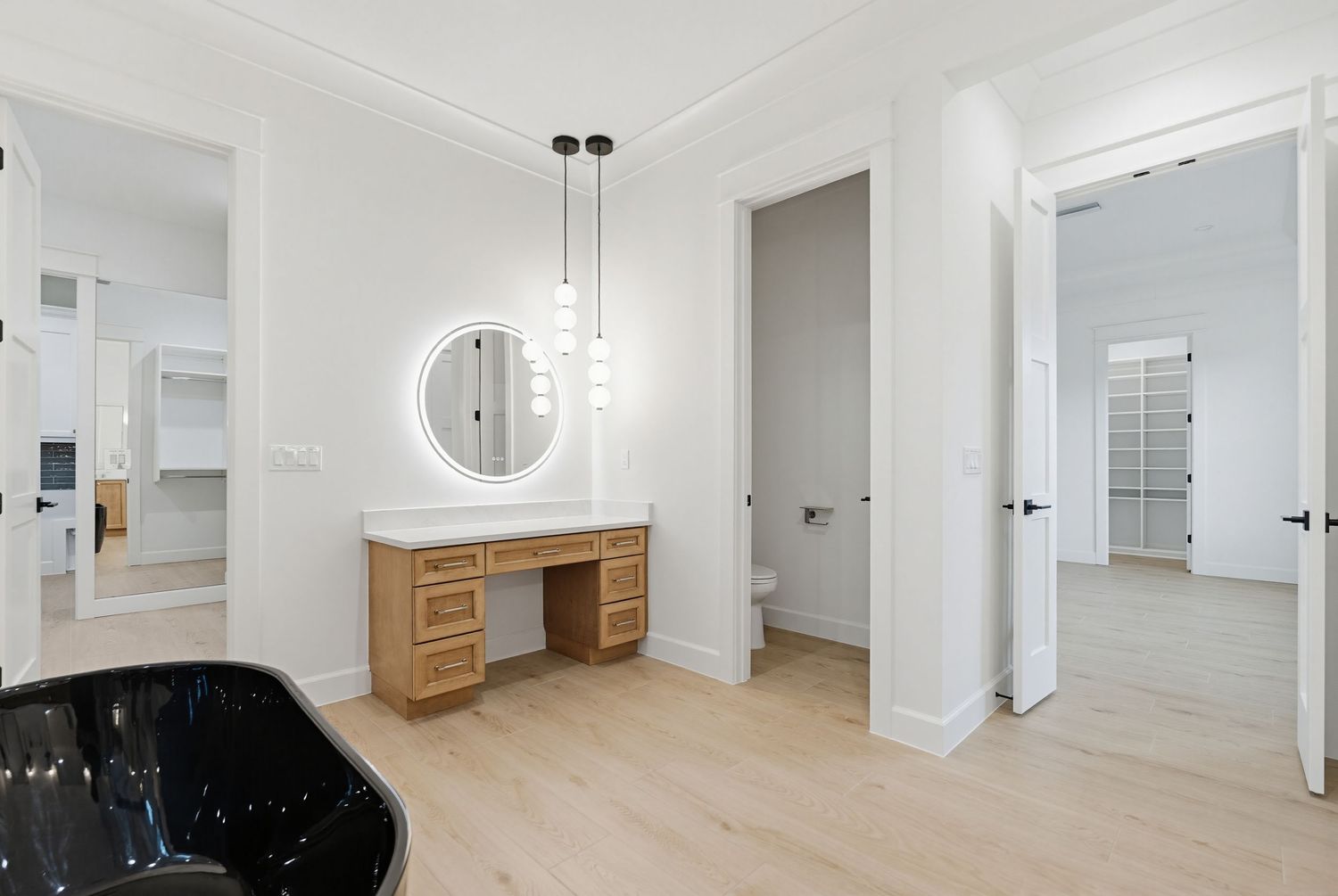 Modern apartment interior with light hardwood floors and white walls showcases a minimalist open concept design.