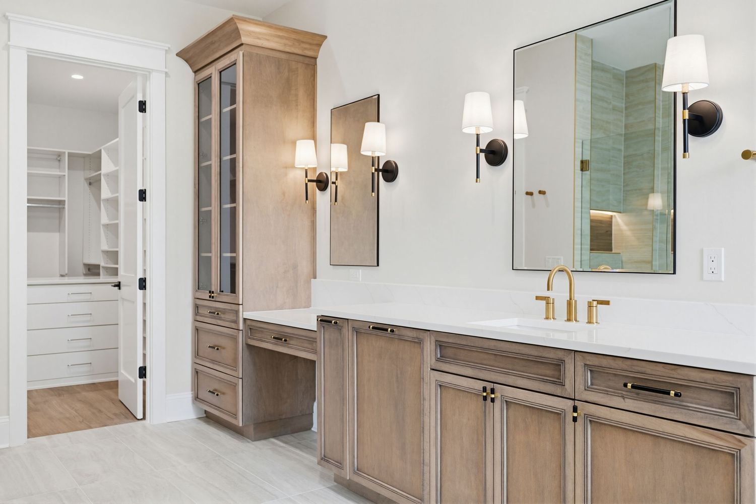 Modern bathroom interior with light wood vanity, white walls, and brass fixtures features a sleek minimalist design.