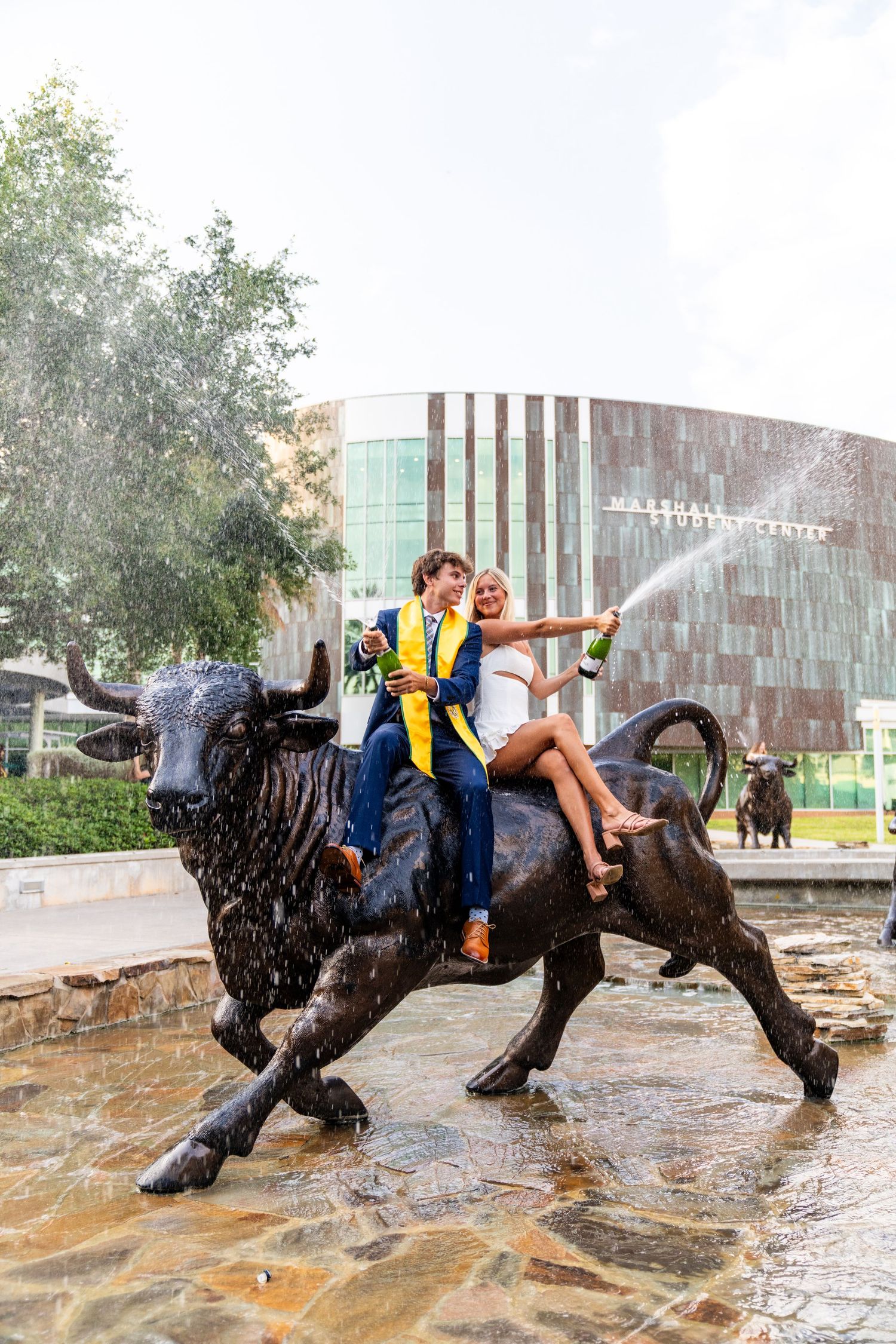 A sequence of action shots showing a person falling and sliding on a wet surface in front of a modern building.