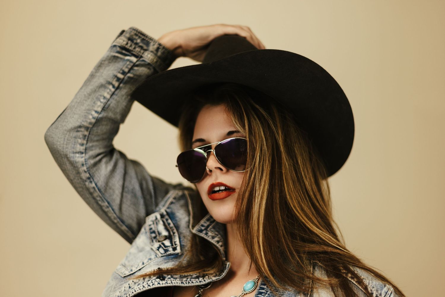 Stylish woman in black hat and red lipstick posing with sunglasses in multiple glamorous fashion portraits.