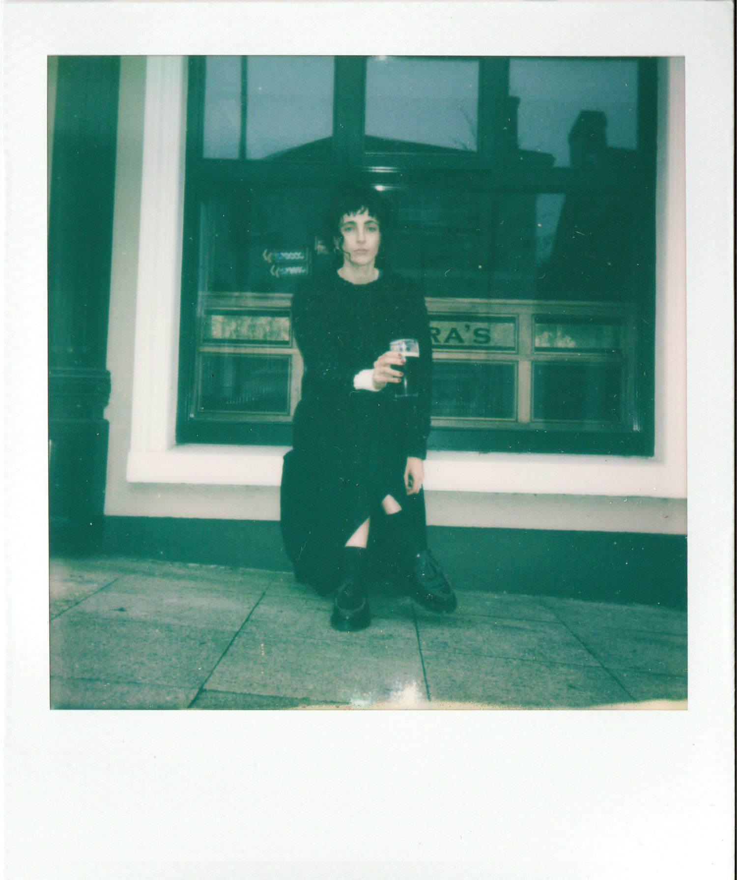 Three vintage-style polaroid photos showing someone in dark clothing sitting outside a building entrance.