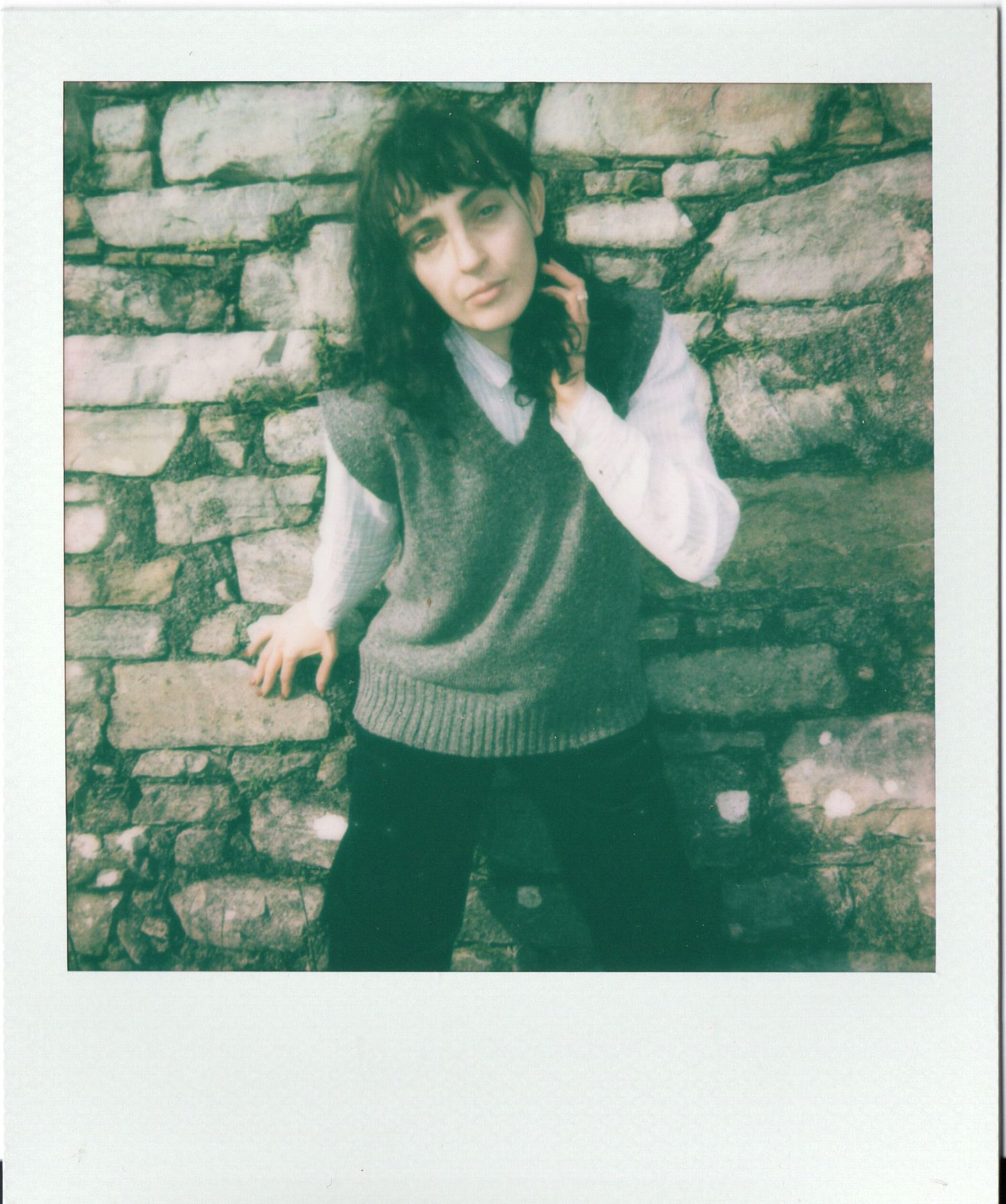 Vintage sepia-toned portrait series against a brick wall background showing artistic poses in moody lighting.