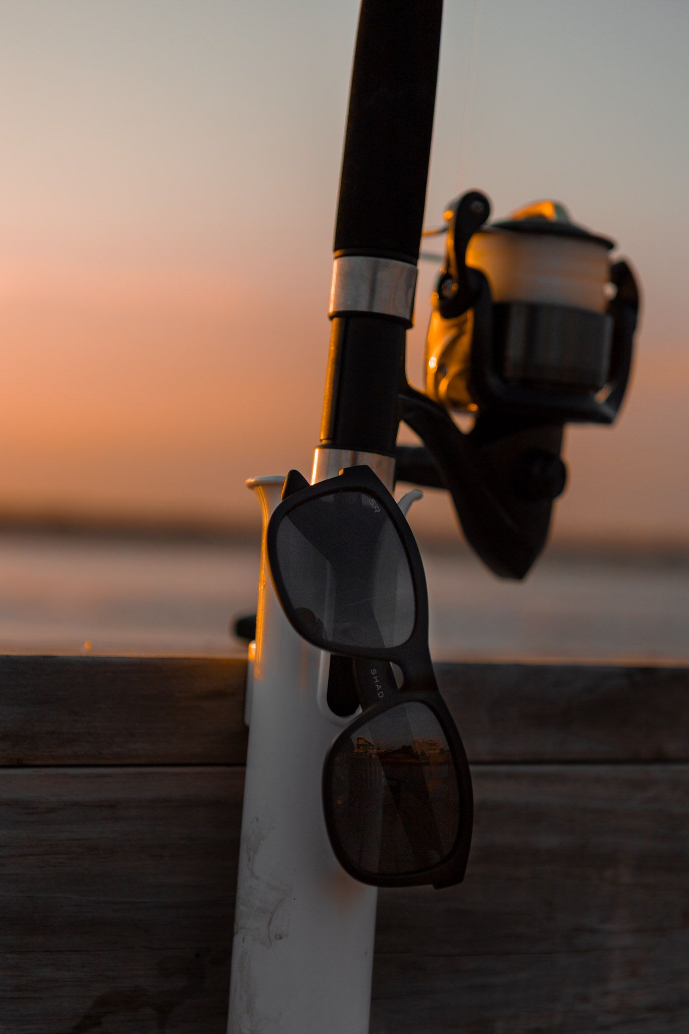 sunglasses and a fishing pole at sunset