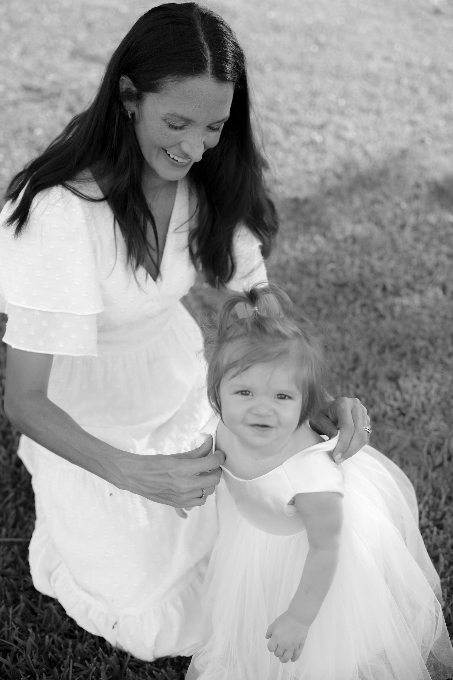 mom helping daughter put on dress first birthday photos black and white mother daughter