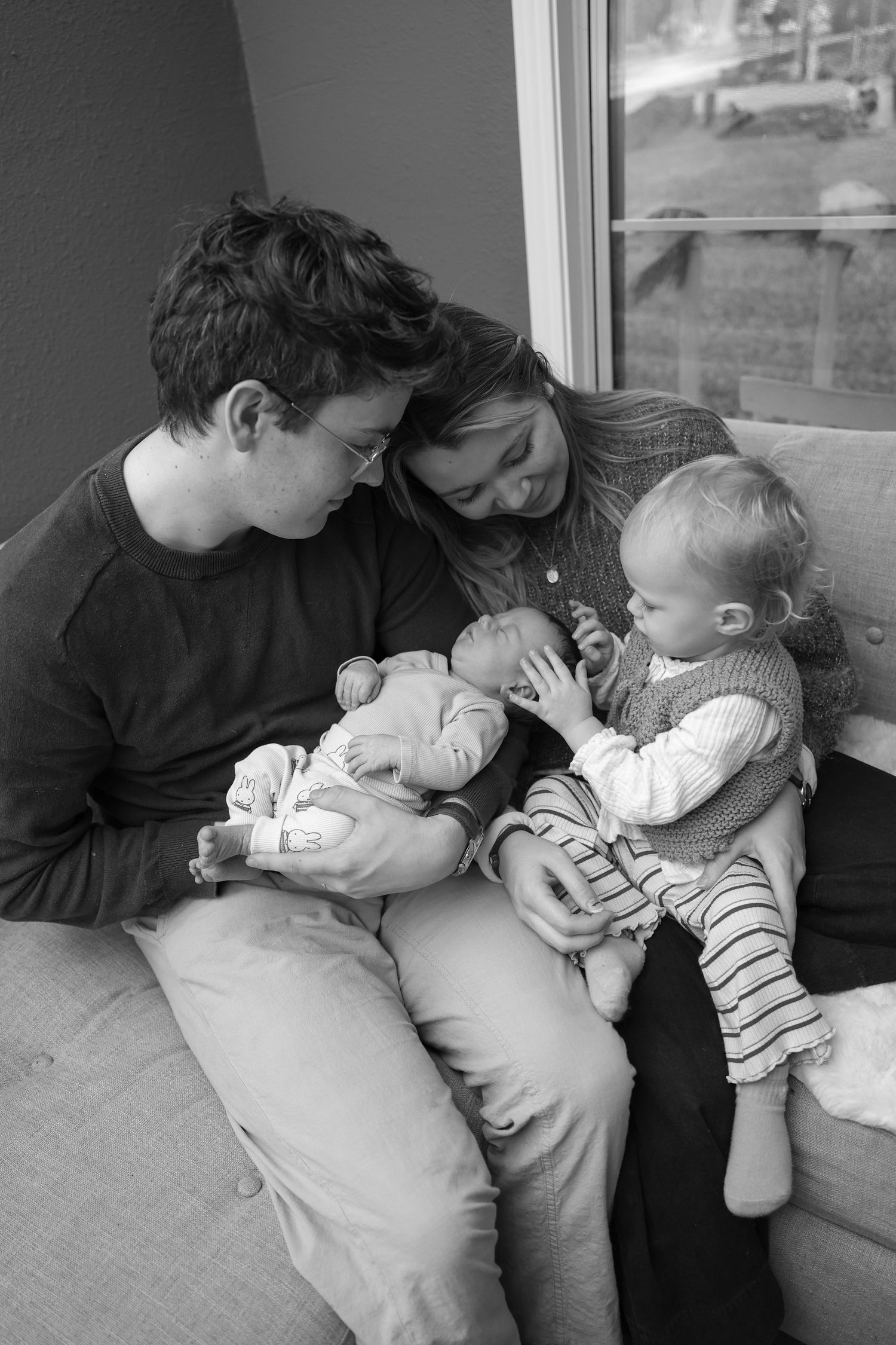 friendswood family black and white newborn toddler mom dad snuggled on the couch