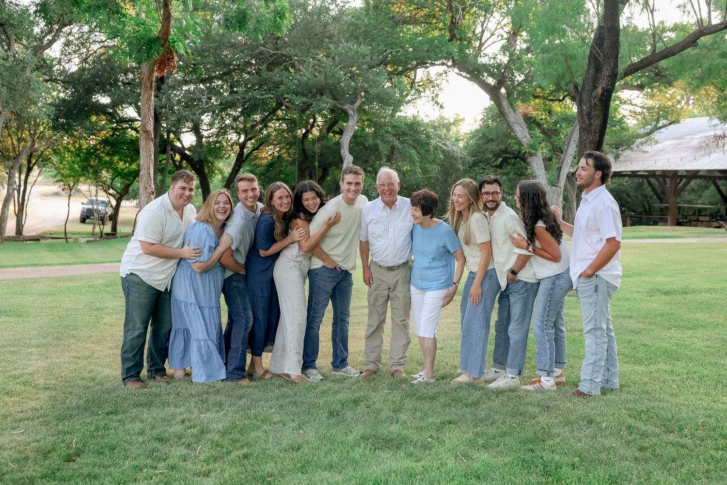 family grown children and grandparents hugging and laughing in nature austin texas family photo session