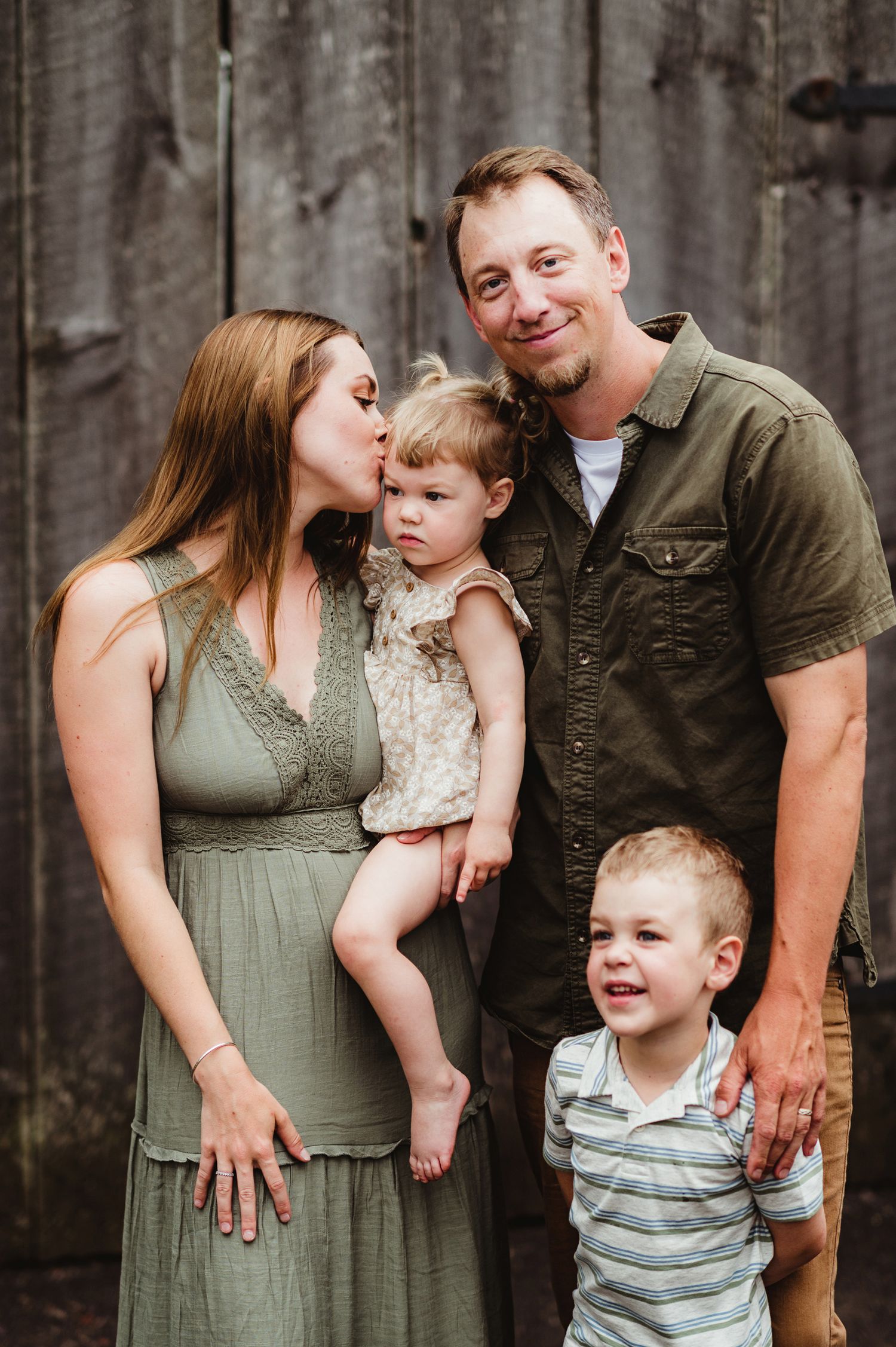 Family portrait series showing sweet moments against rustic wooden wall backdrop.