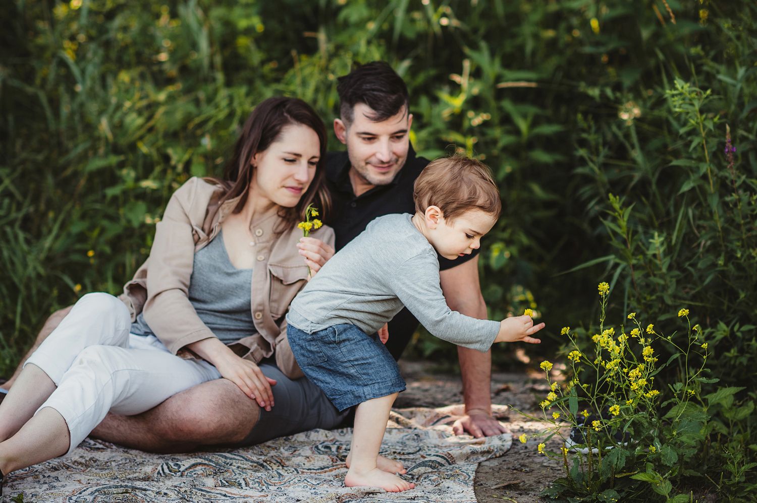 Family enjoying a casual moment together on stone surface outdoors.