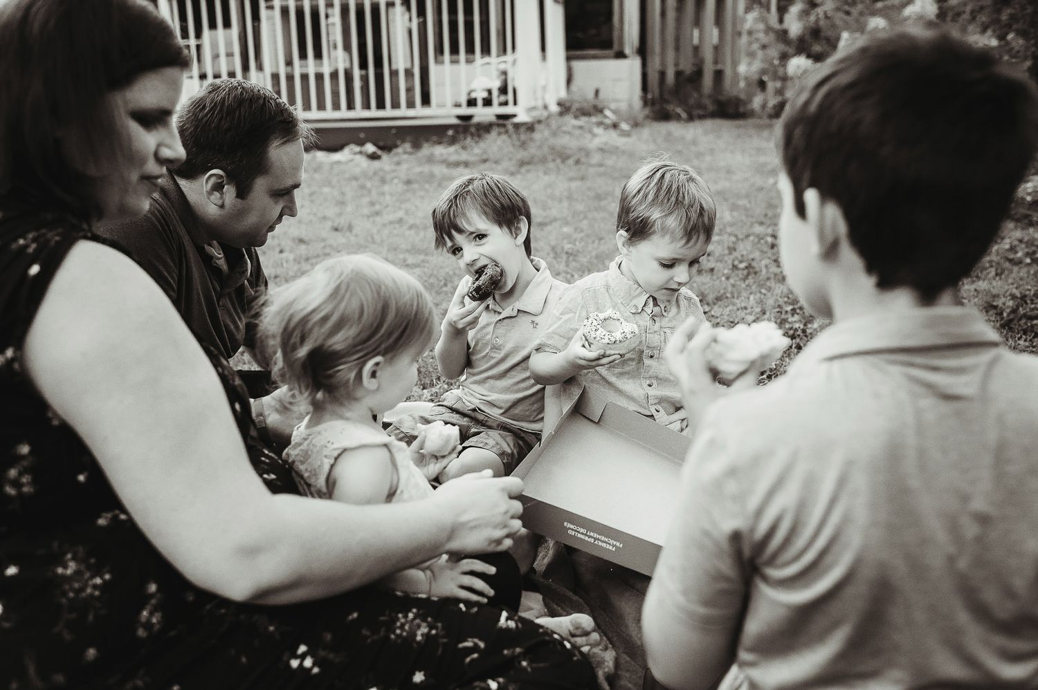 Vintage black and white photograph of family picnic gathering outdoors.