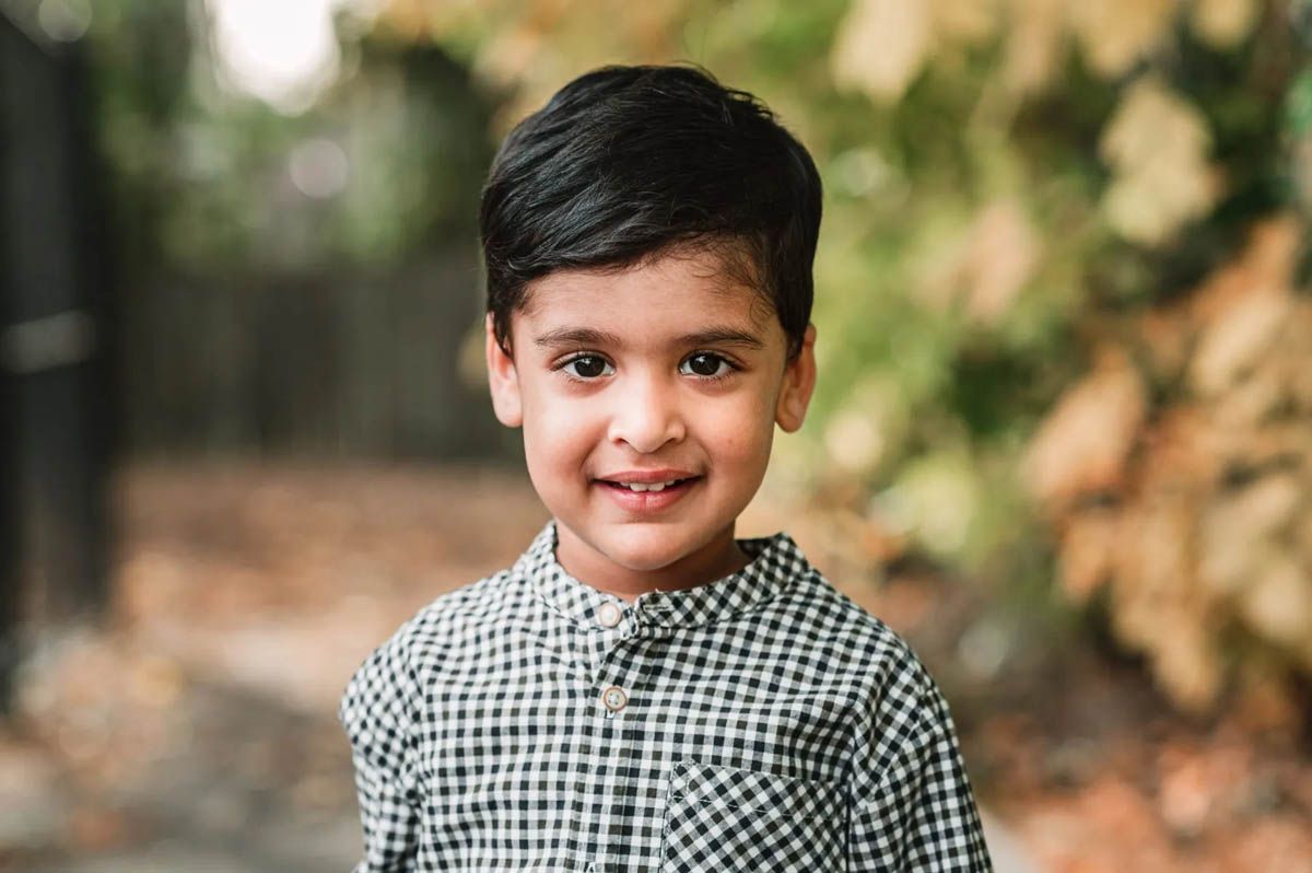 School portraits with students wearing uniforms against blurred outdoor background.