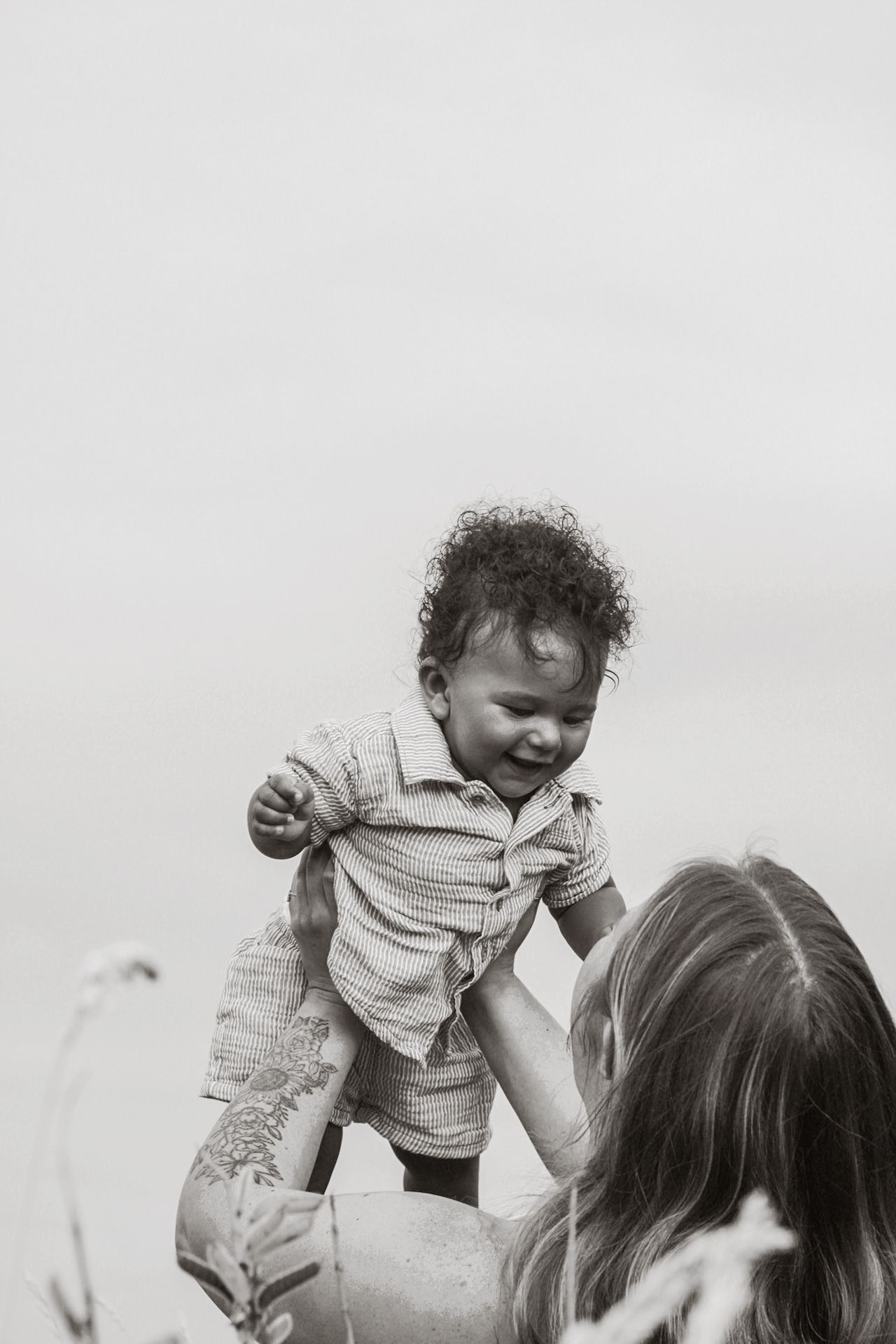 Black and white candid photo showing joyful interaction in natural light.