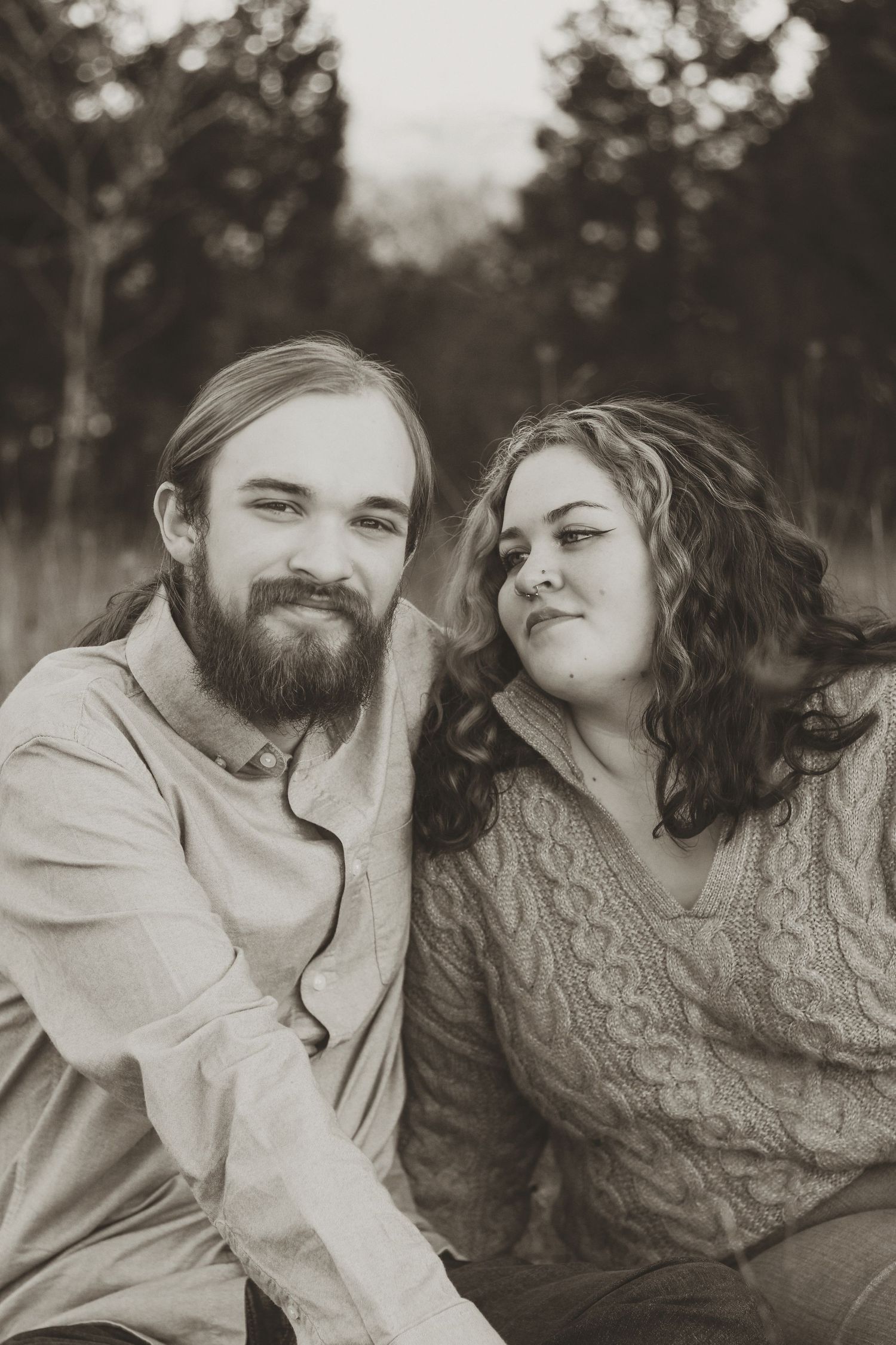 A romantic black and white photo series showing a couple embracing and sharing tender moments outdoors.