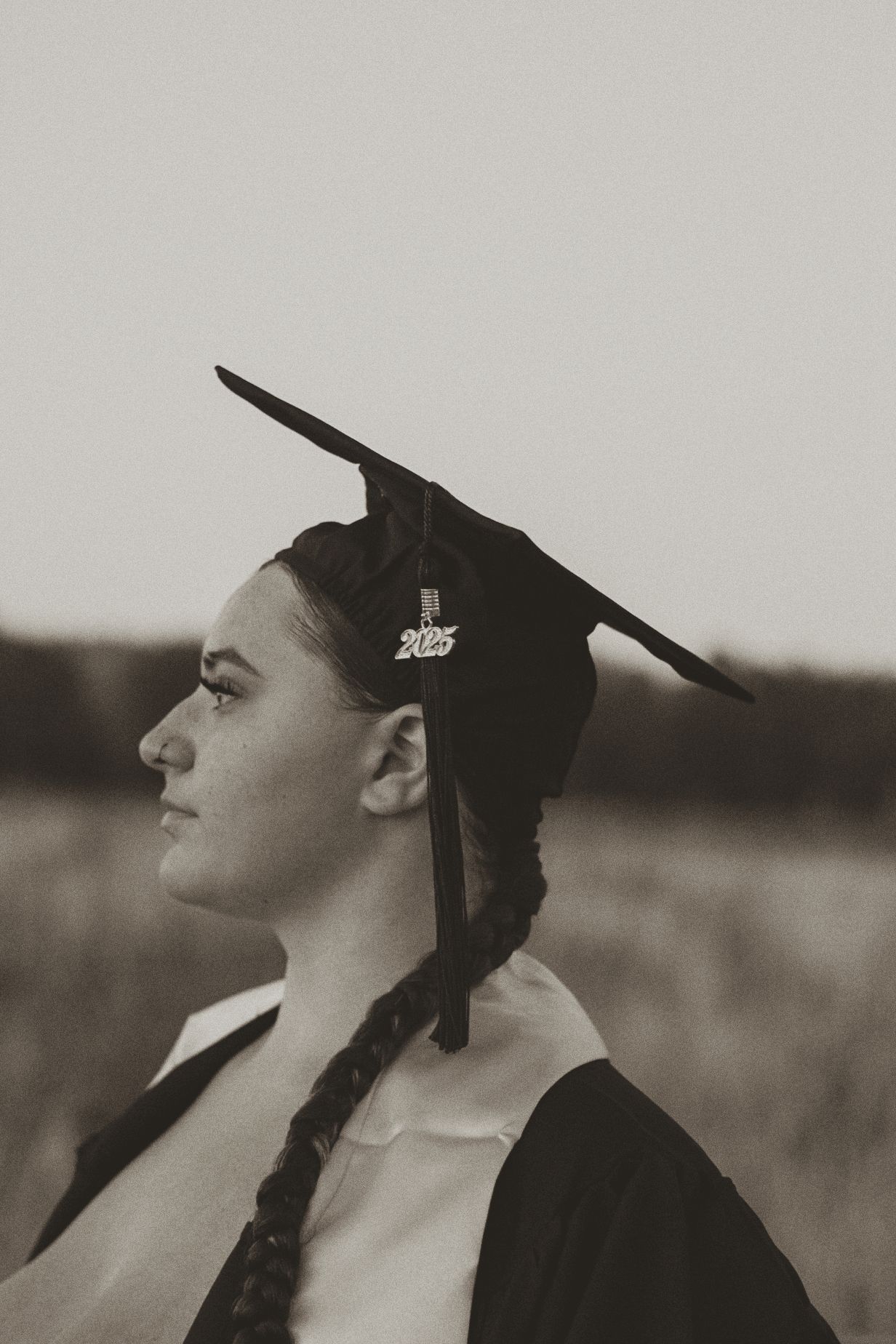 A vintage sepia photograph shows a profile view of a figure in traditional dress looking upward.
