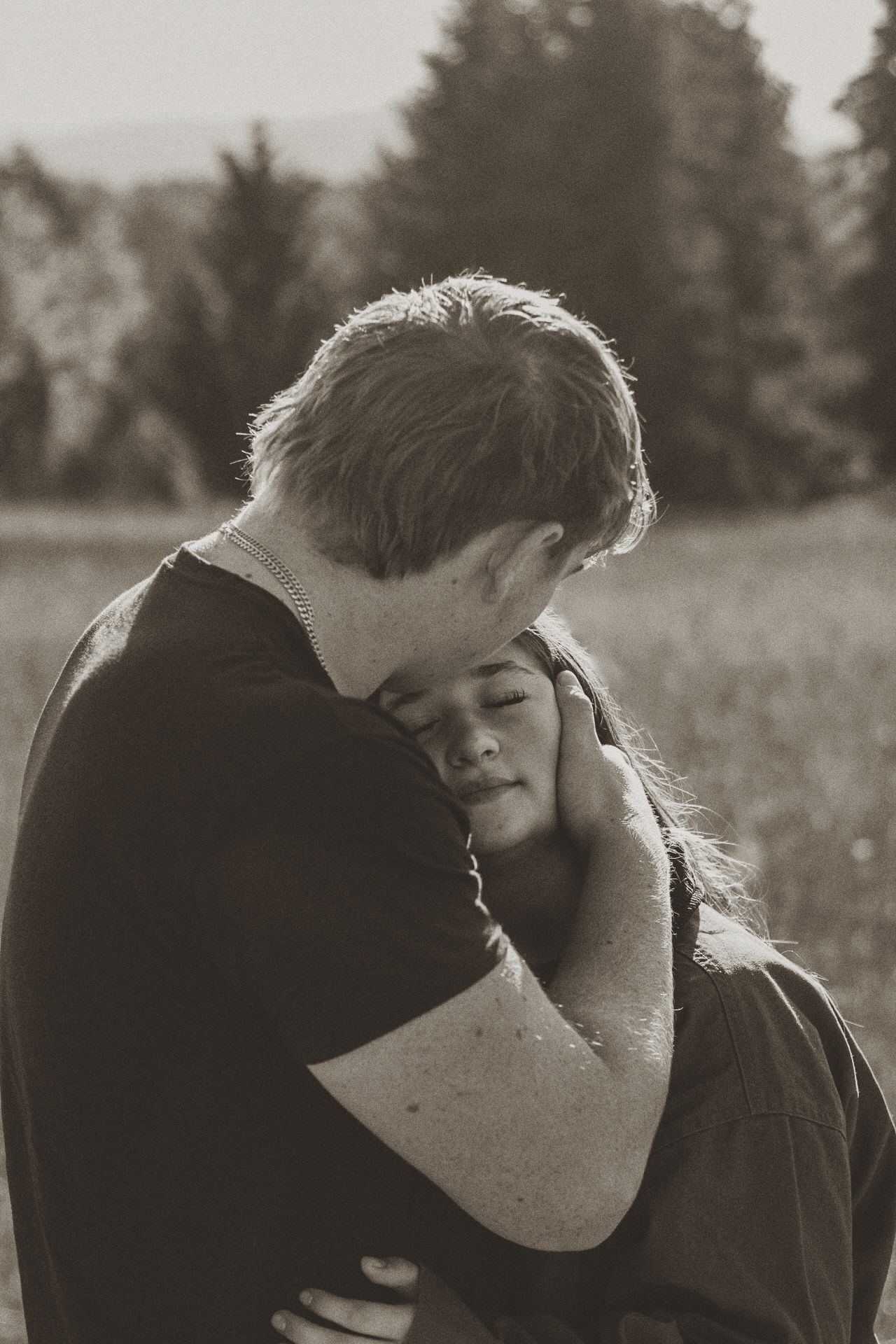 Intimate black and white portrait capturing a tender embrace in nature.