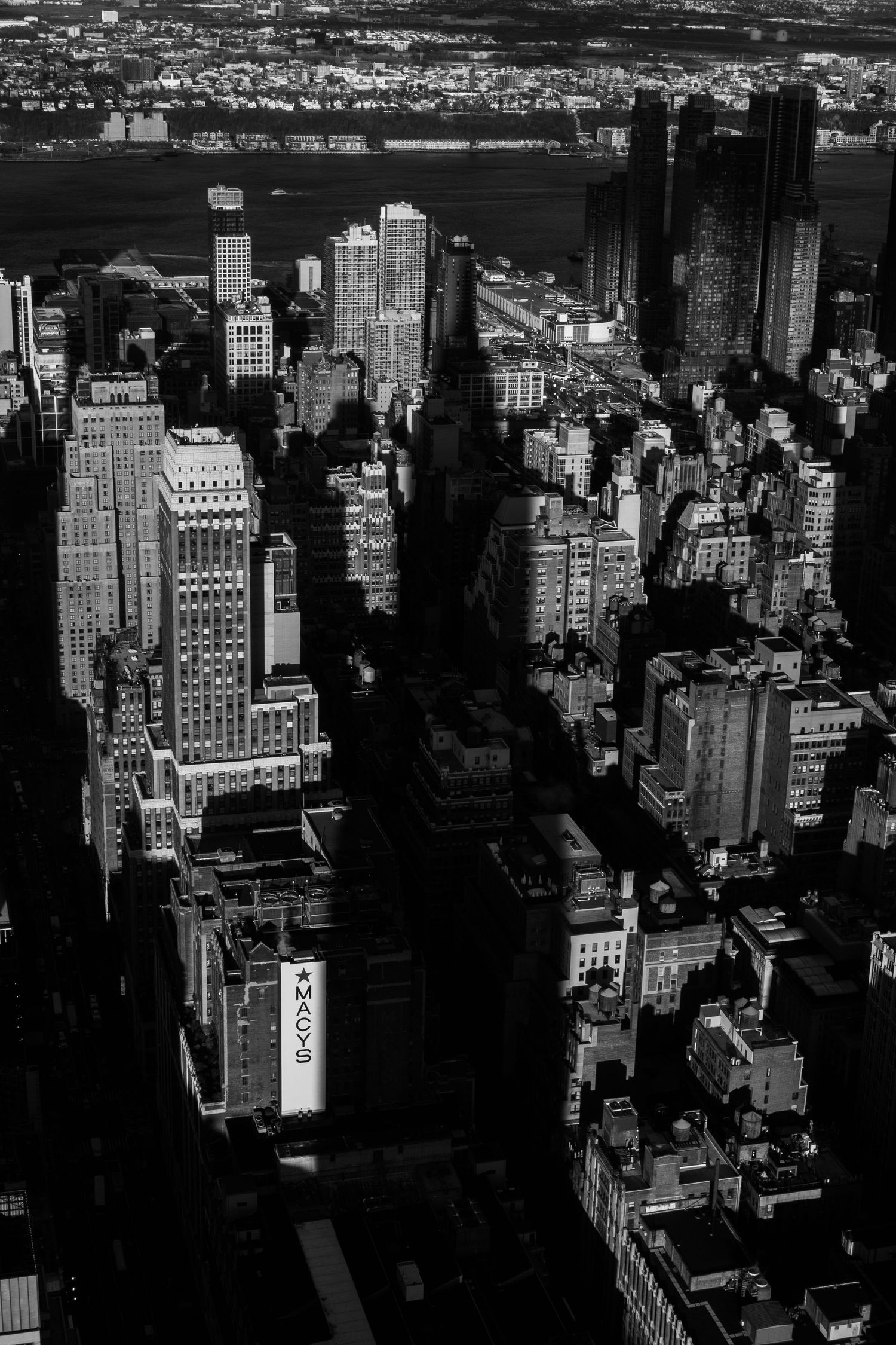 Aerial view of Manhattan skyscrapers and city blocks in black and white.