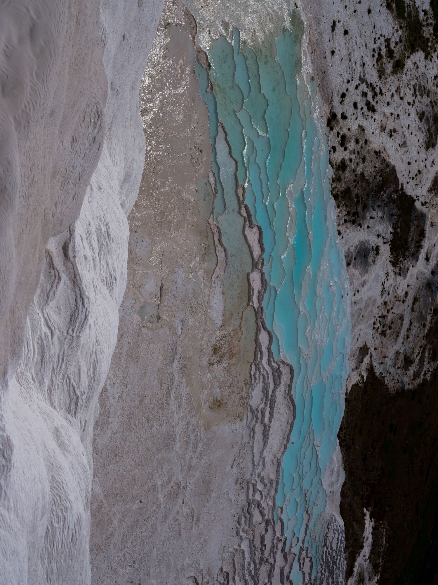Abstract landscape featuring contrasting textures of white, grey, and turquoise patterns.