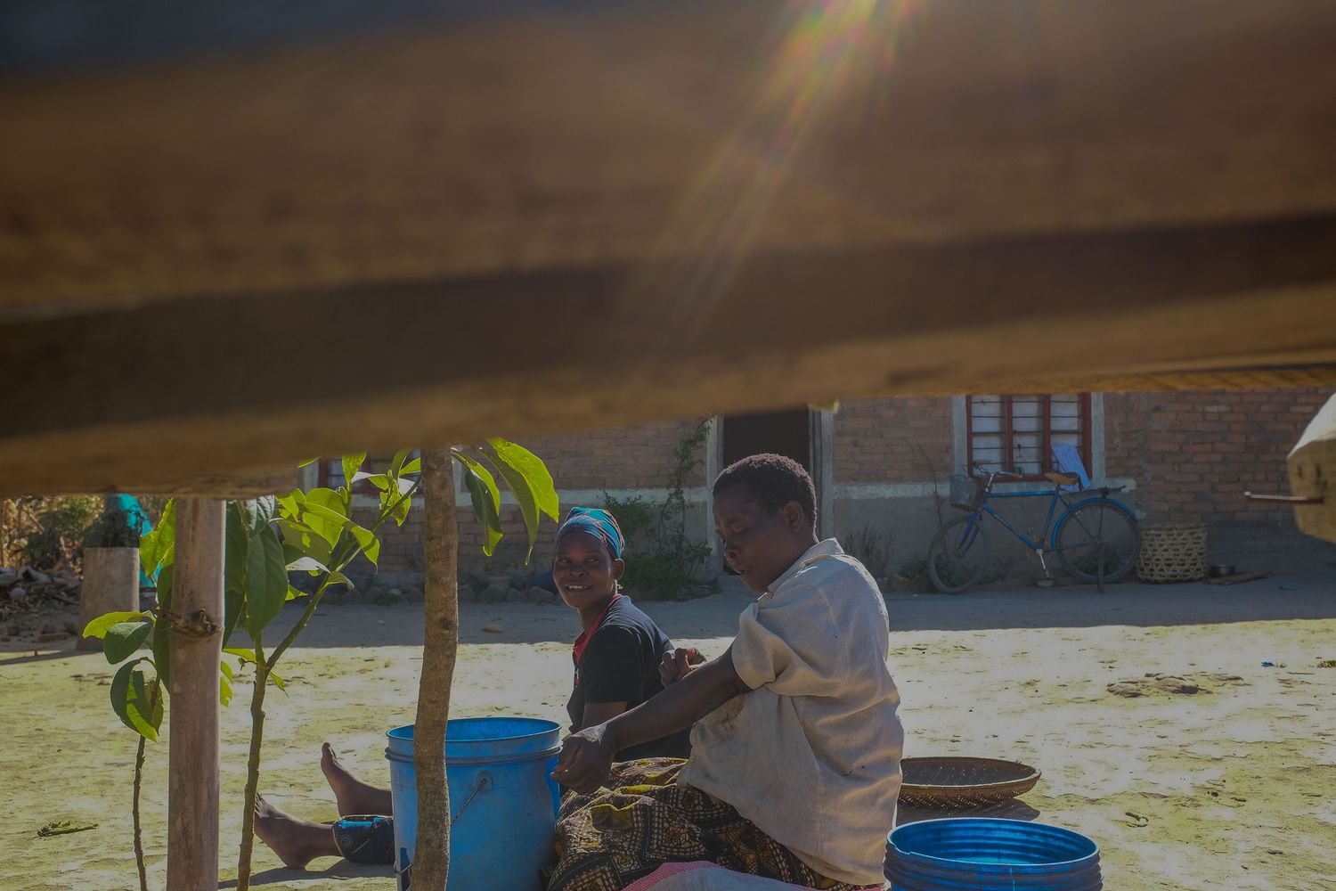 People preparing food outdoors near traditional buildings.