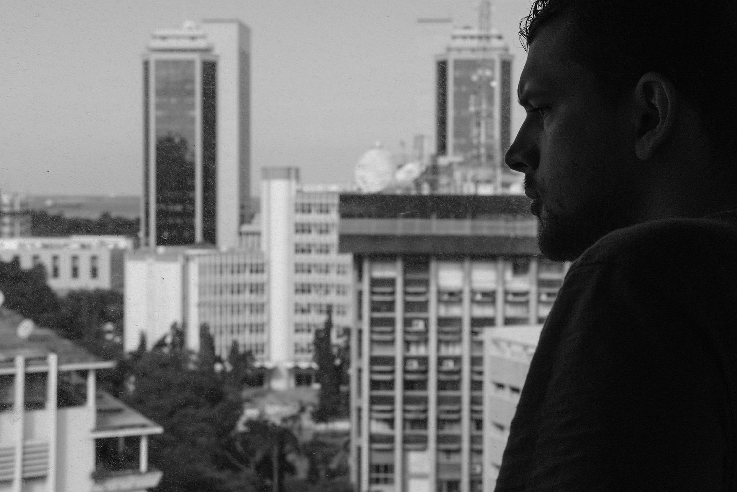 Urban skyline silhouetted against bright sky with buildings in background.