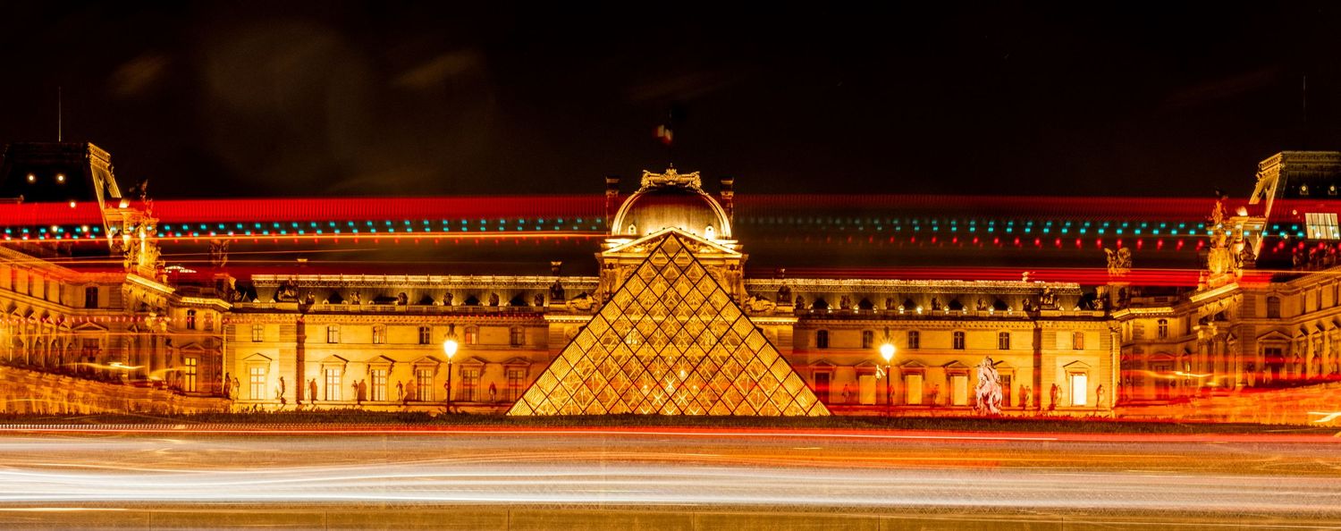 Illuminated historic buildings and landmarks glowing at night in warm golden light.