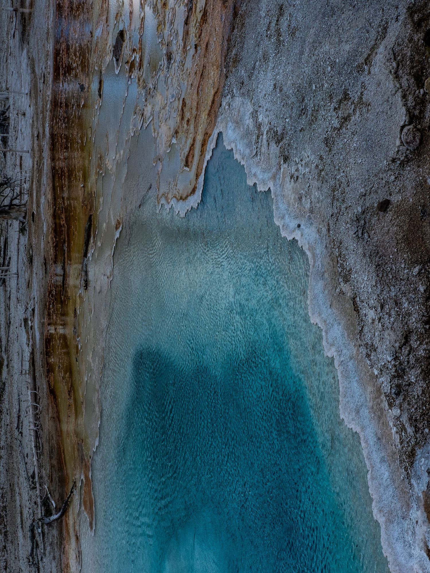 Turquoise mineral deposits form patterns against a weathered rocky surface.