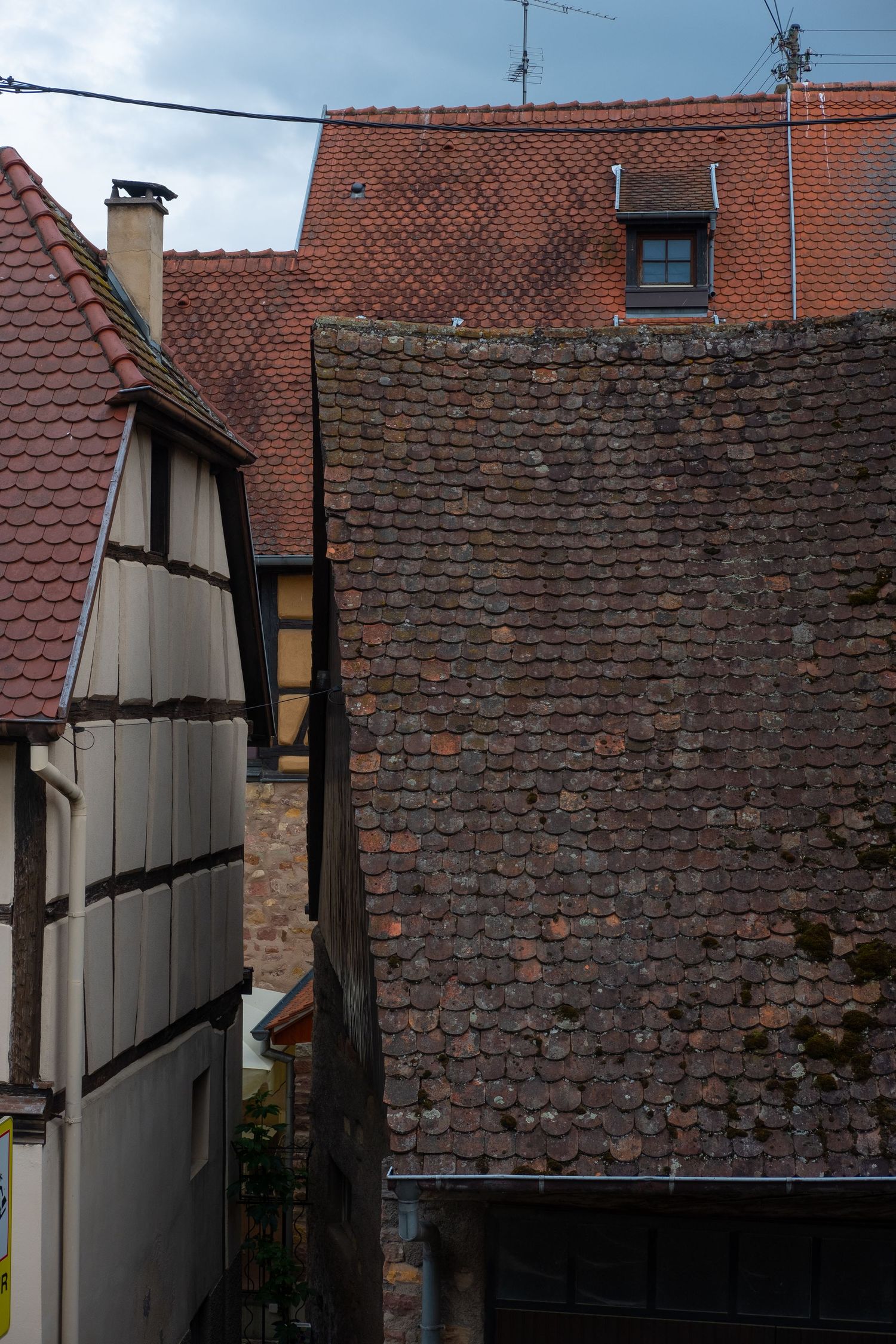 Old brick walls and tiled rooftops creating geometric patterns in urban architecture.
