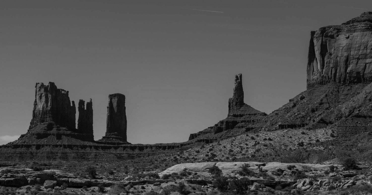 Panoramic view of iconic Monument Valley buttes and mesas in dramatic lighting.
