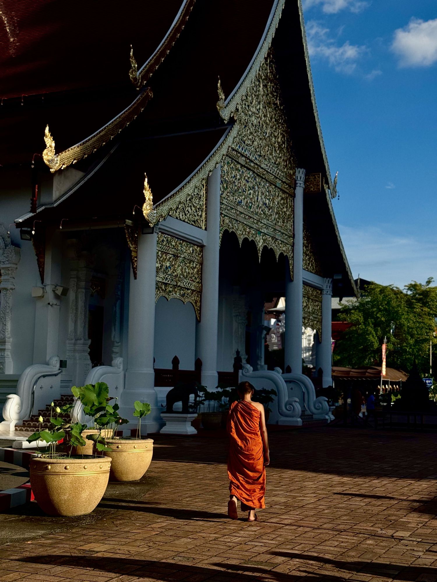 Traditional Thai temple architecture with ornate details against blue sky.