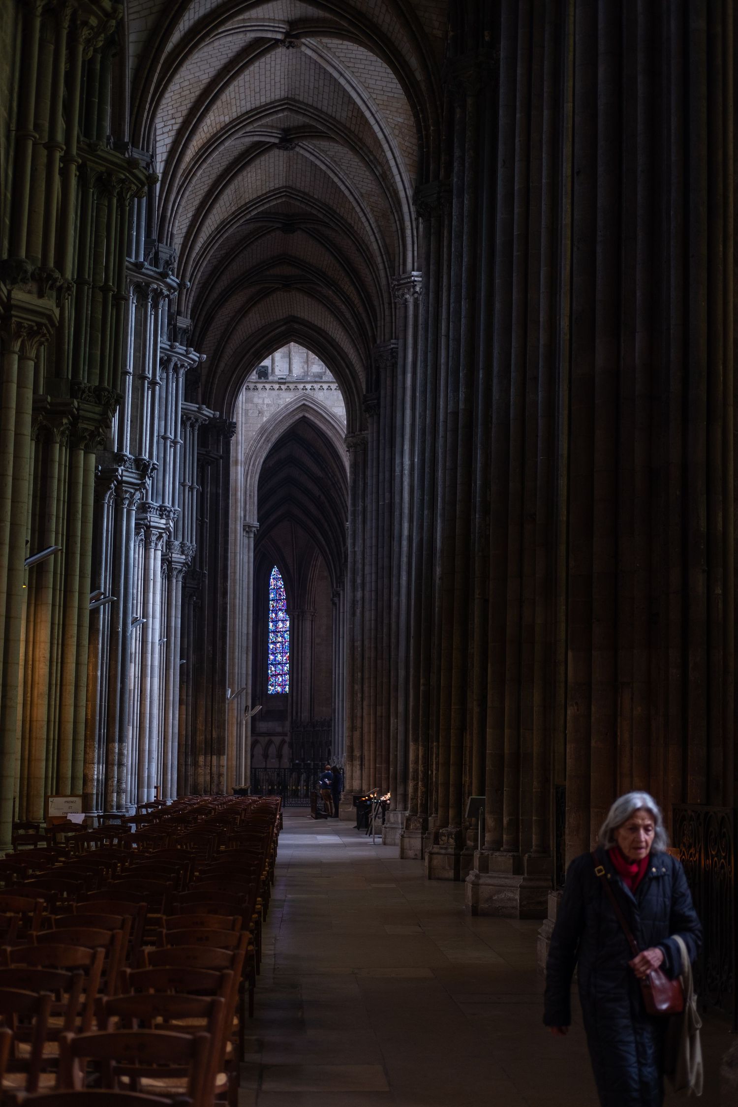 Gothic cathedral interior with soaring arches and dramatic lighting through stained glass windows.