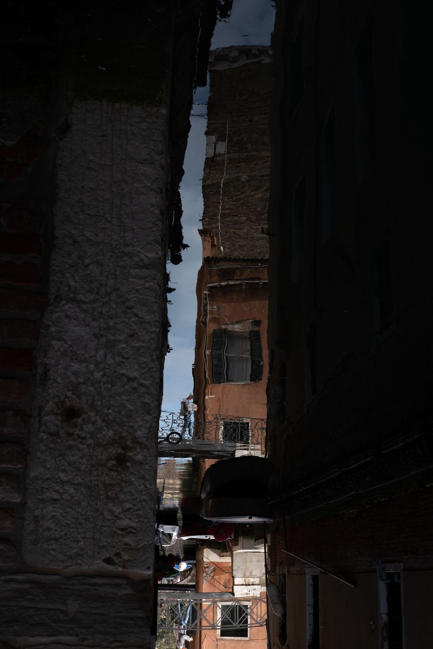 Narrow alleyway between tall buildings with sunlight filtering through the urban canyon.