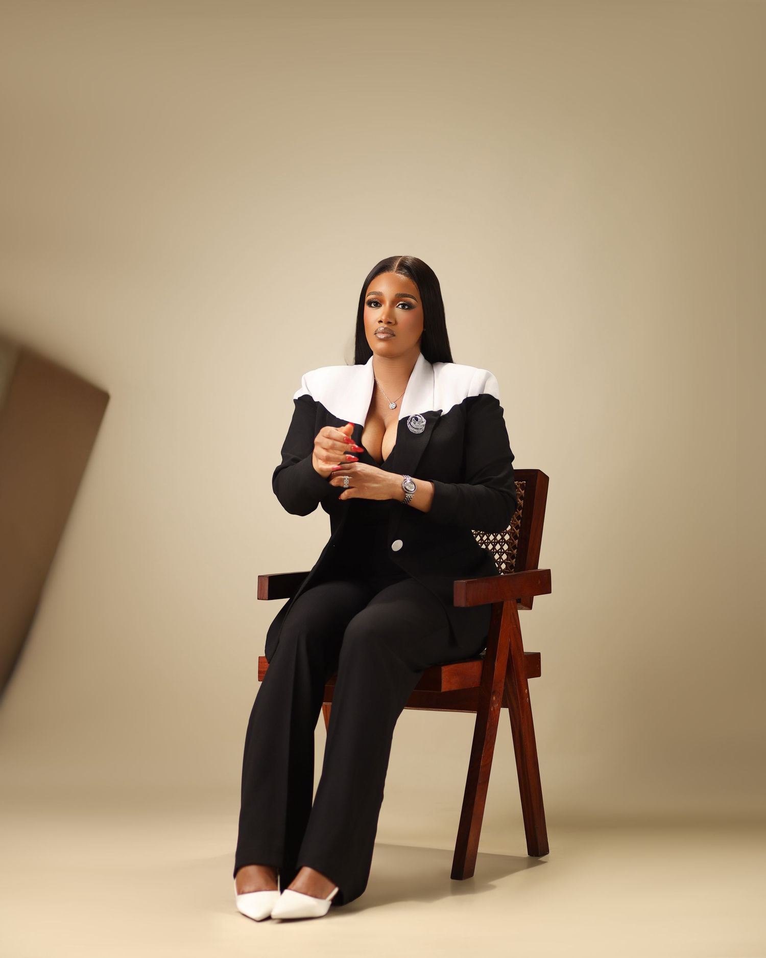 Professional business portraits featuring a person in a black suit seated on a wooden chair.