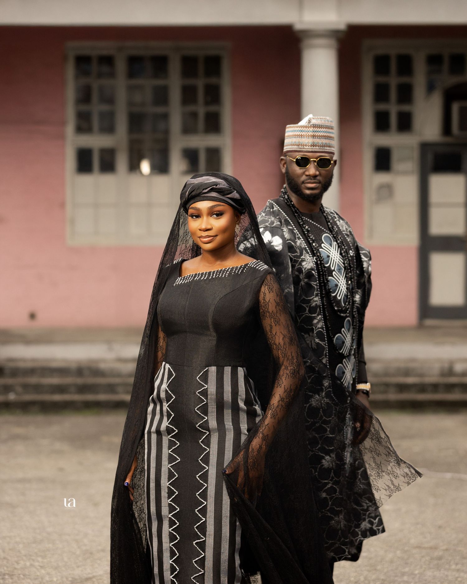 Elegant couple in traditional black African attire posing for engagement photos.