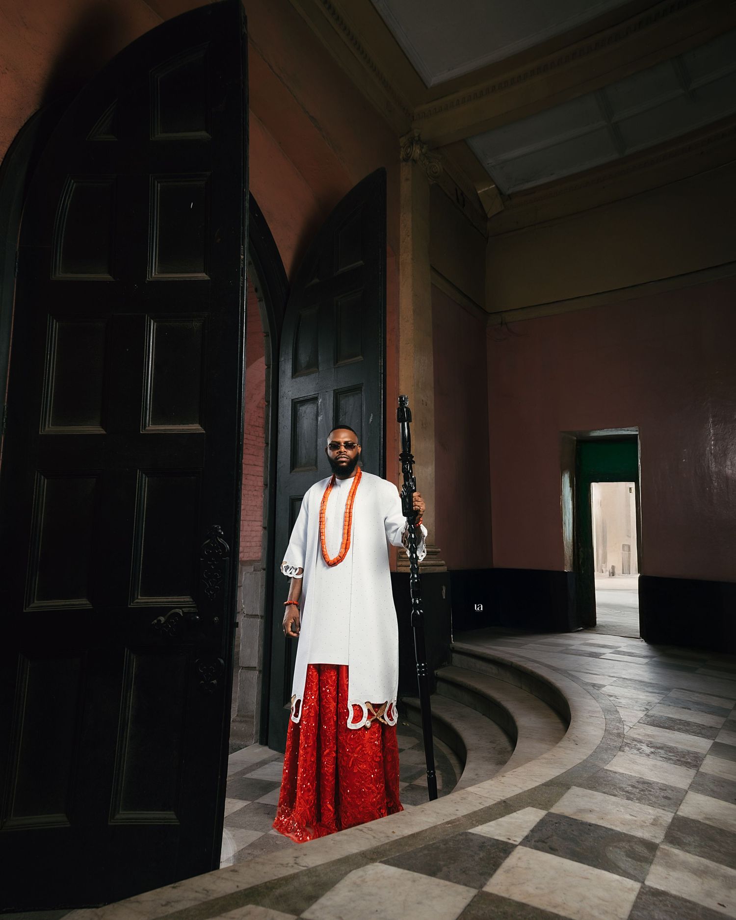 Fashion photography in historic hallway featuring traditional Nigerian attire.