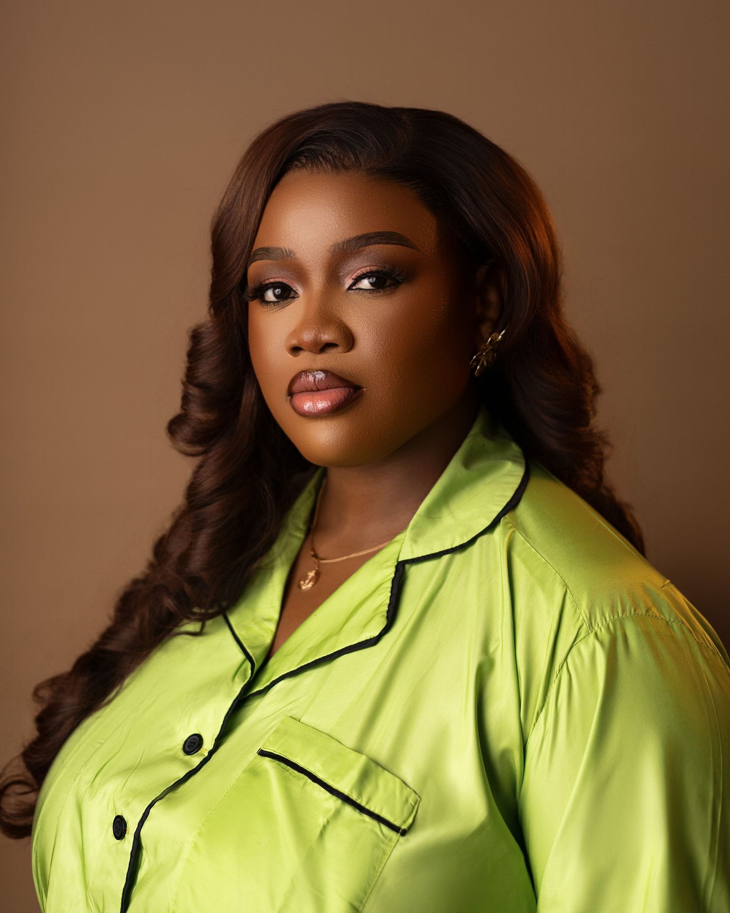 Fashion portrait series showcasing a bright neon yellow collared jacket against a brown backdrop.