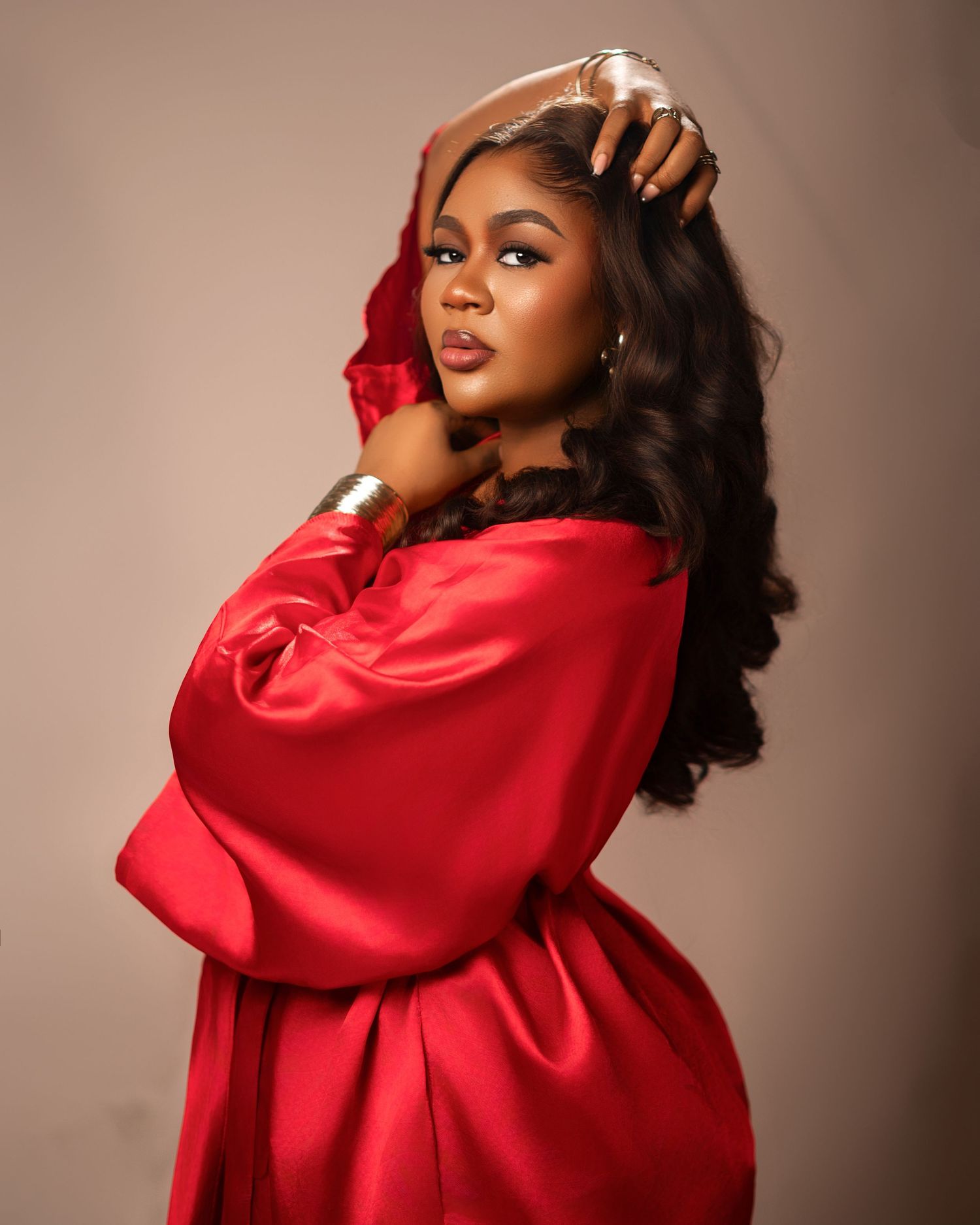 Glamour photography series in vibrant red satin against neutral studio backdrop.