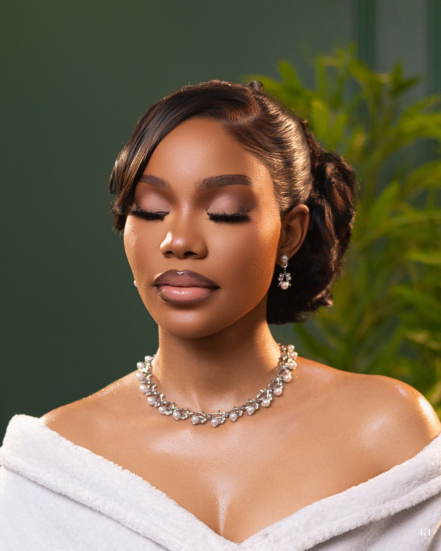 Close-up glamour shot showcasing sparkling necklace and dramatic makeup with soft lighting.