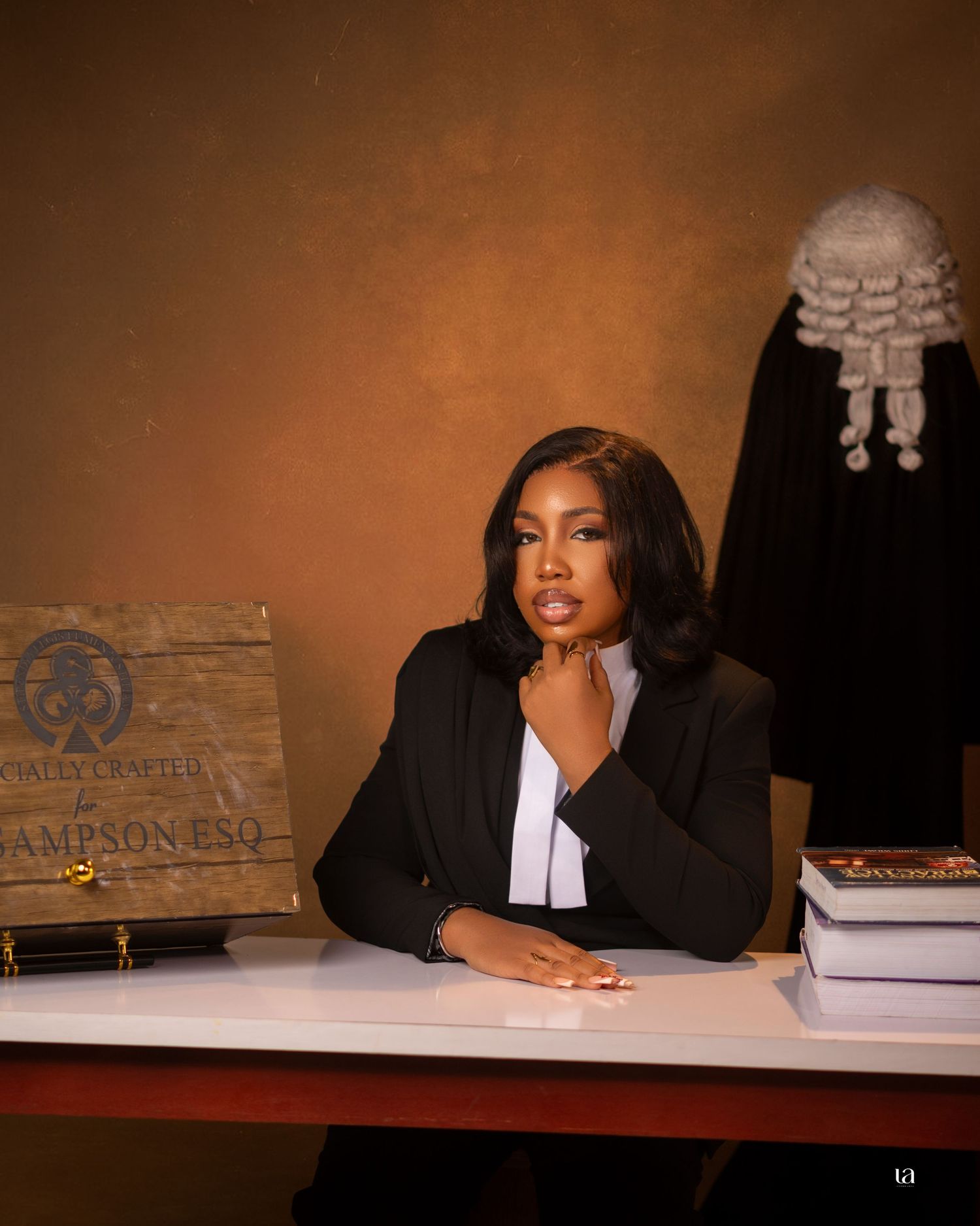 Professional legal-themed photoshoot with law books and judicial attire in warm lighting.