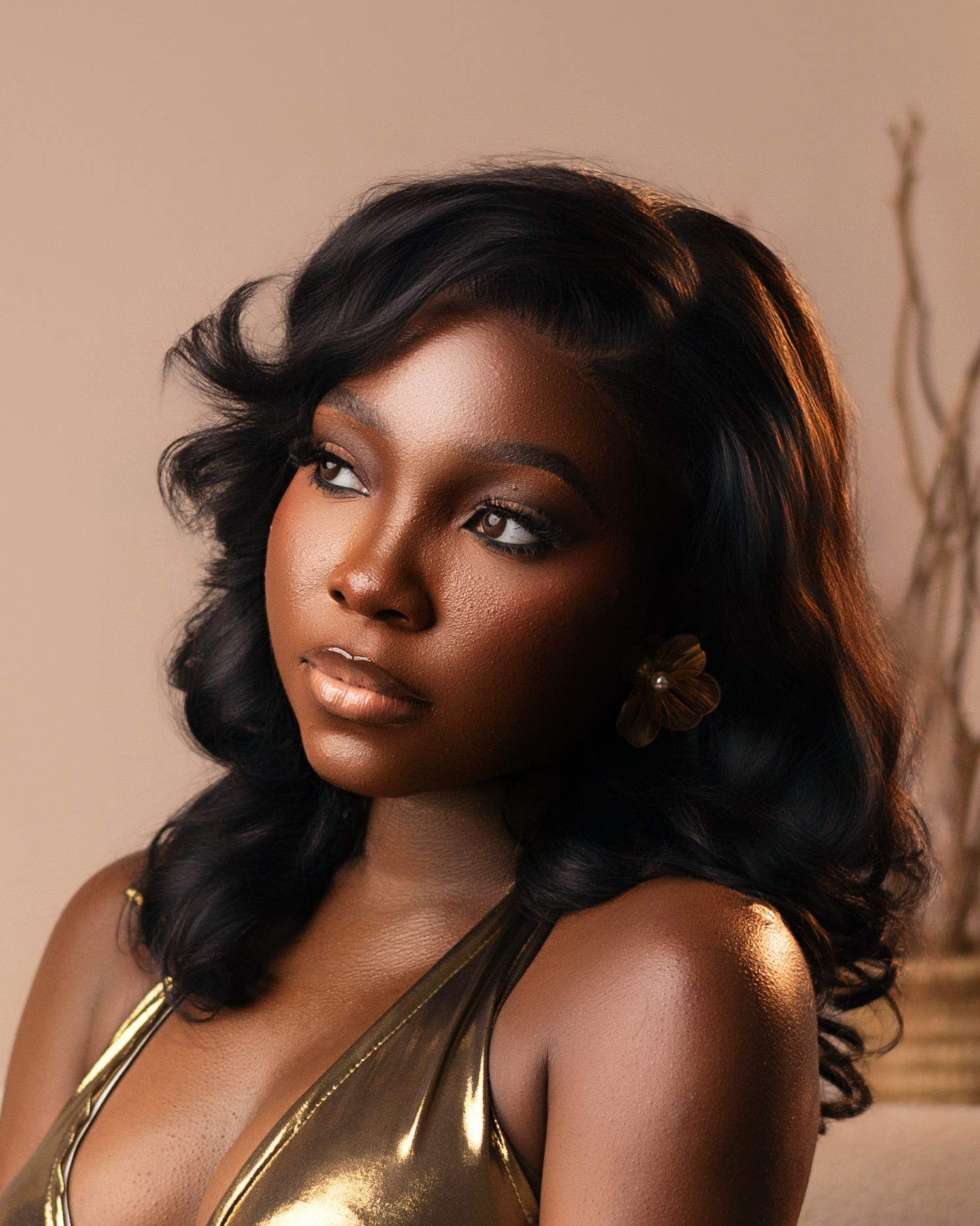 Artistic beauty portraits with gold accents and dramatic lighting on warm background.