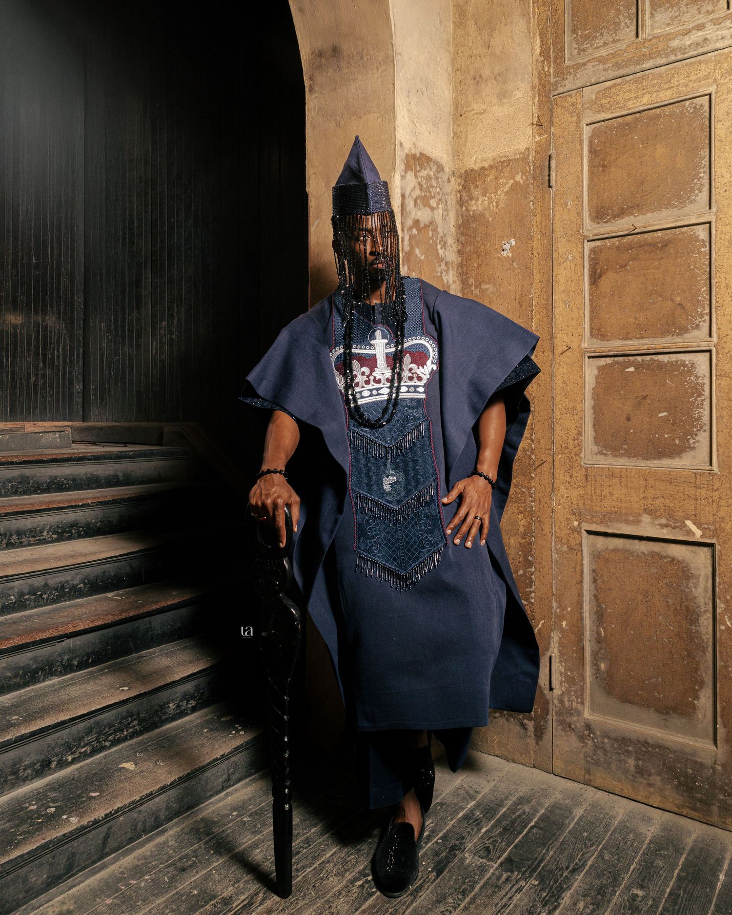 A series of dramatic photos showing a figure in navy blue against a rustic wooden wall and staircase.
