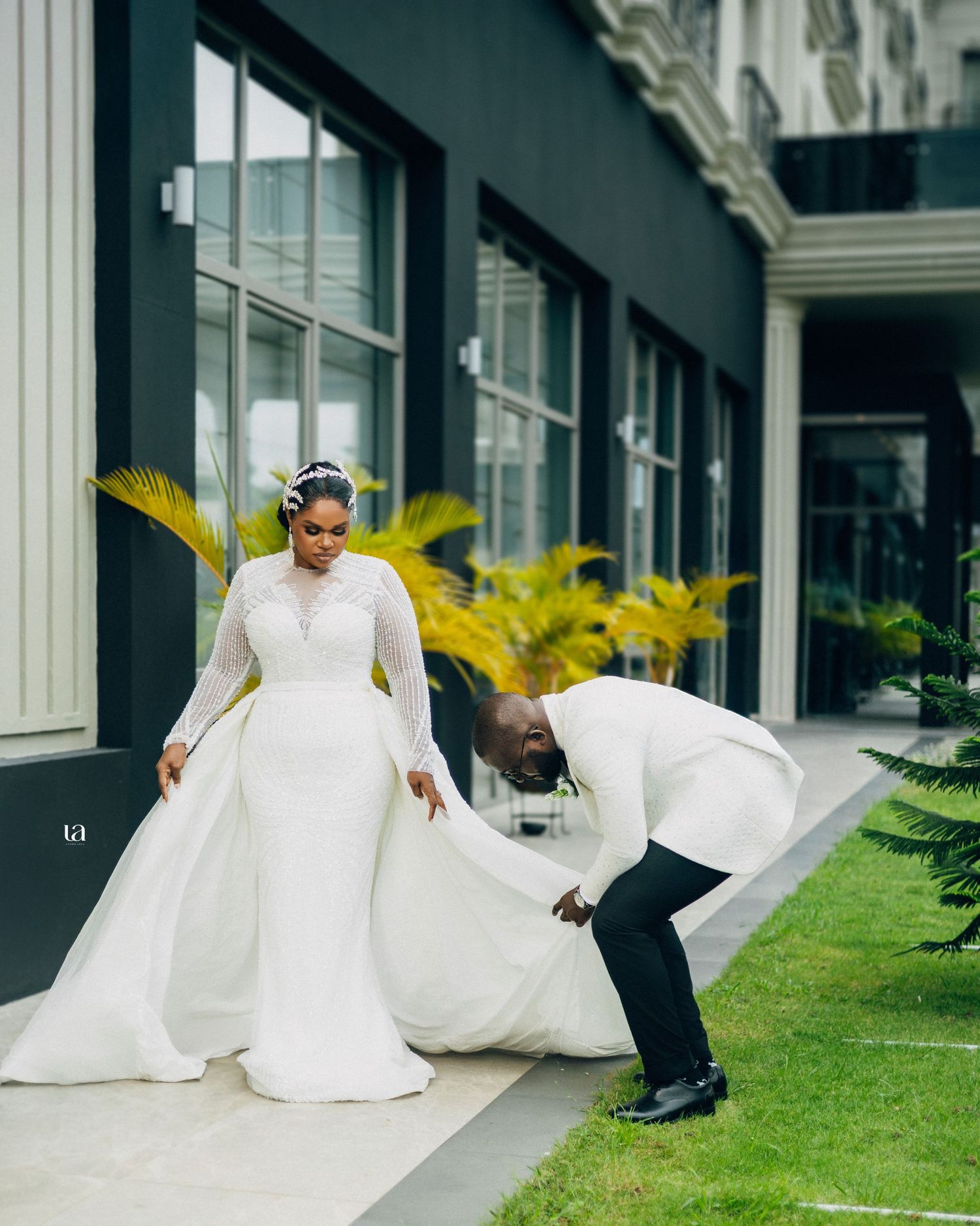 Elegant outdoor wedding photography session with flowing white dress against classic architecture.