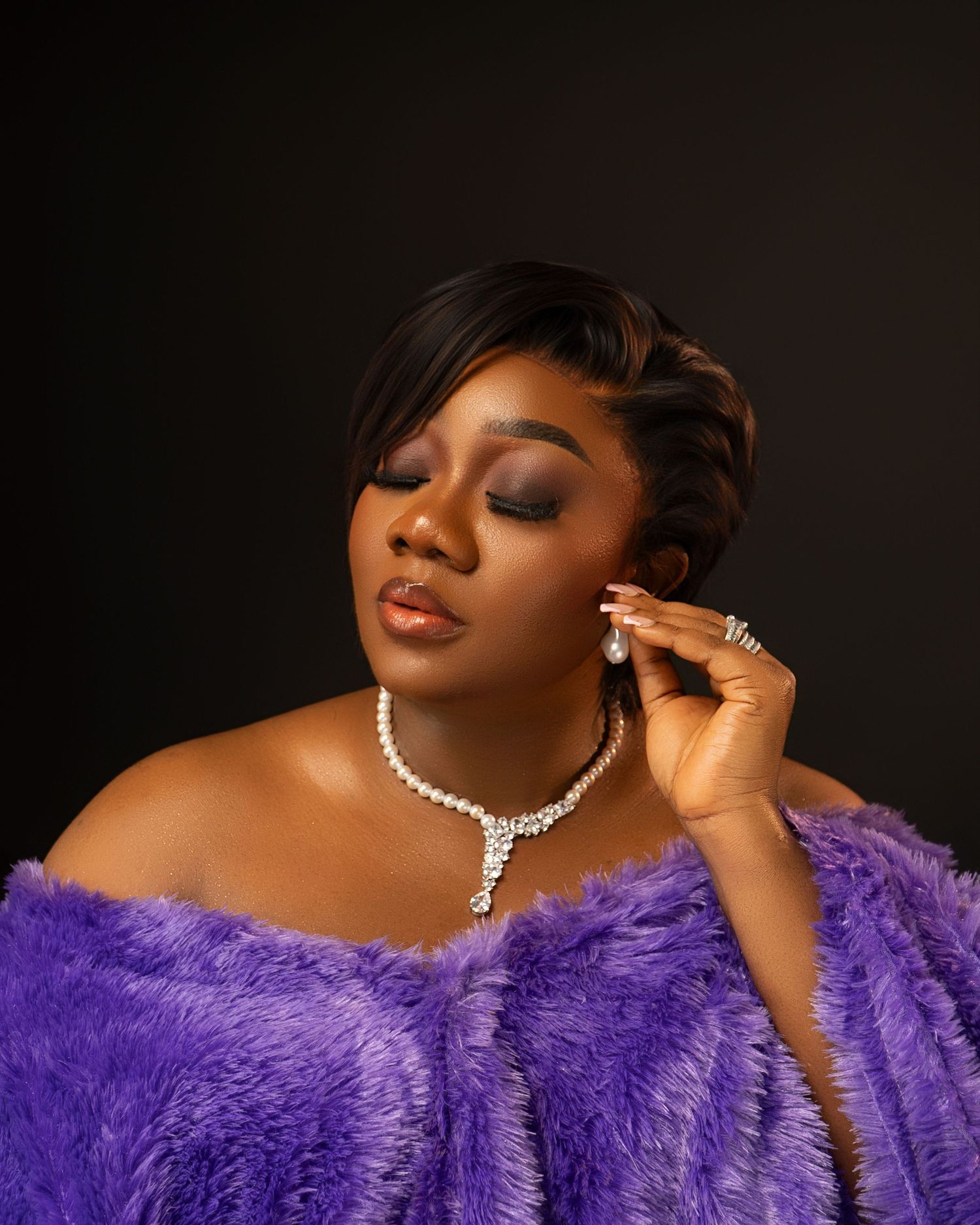 An elegant portrait featuring a purple fur wrap and sparkling diamond necklace.