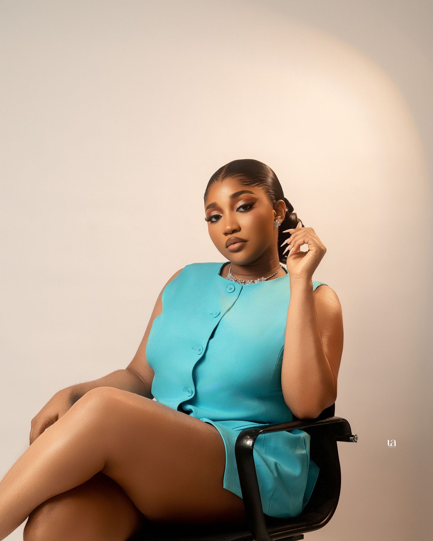 Artistic portrait series featuring a person in a turquoise outfit posing on a chair.