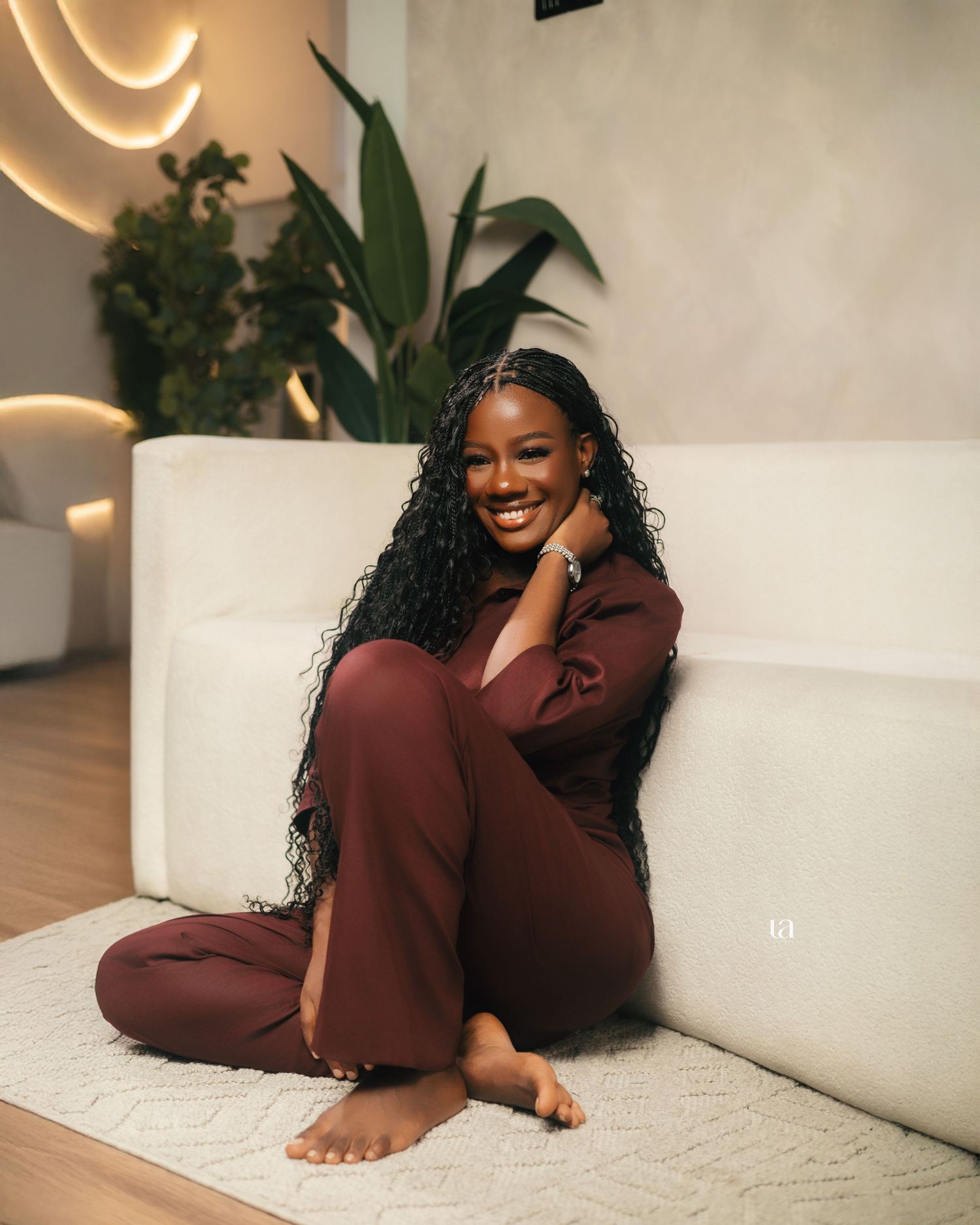 Lifestyle photography featuring a person in burgundy loungewear relaxing on a white couch.