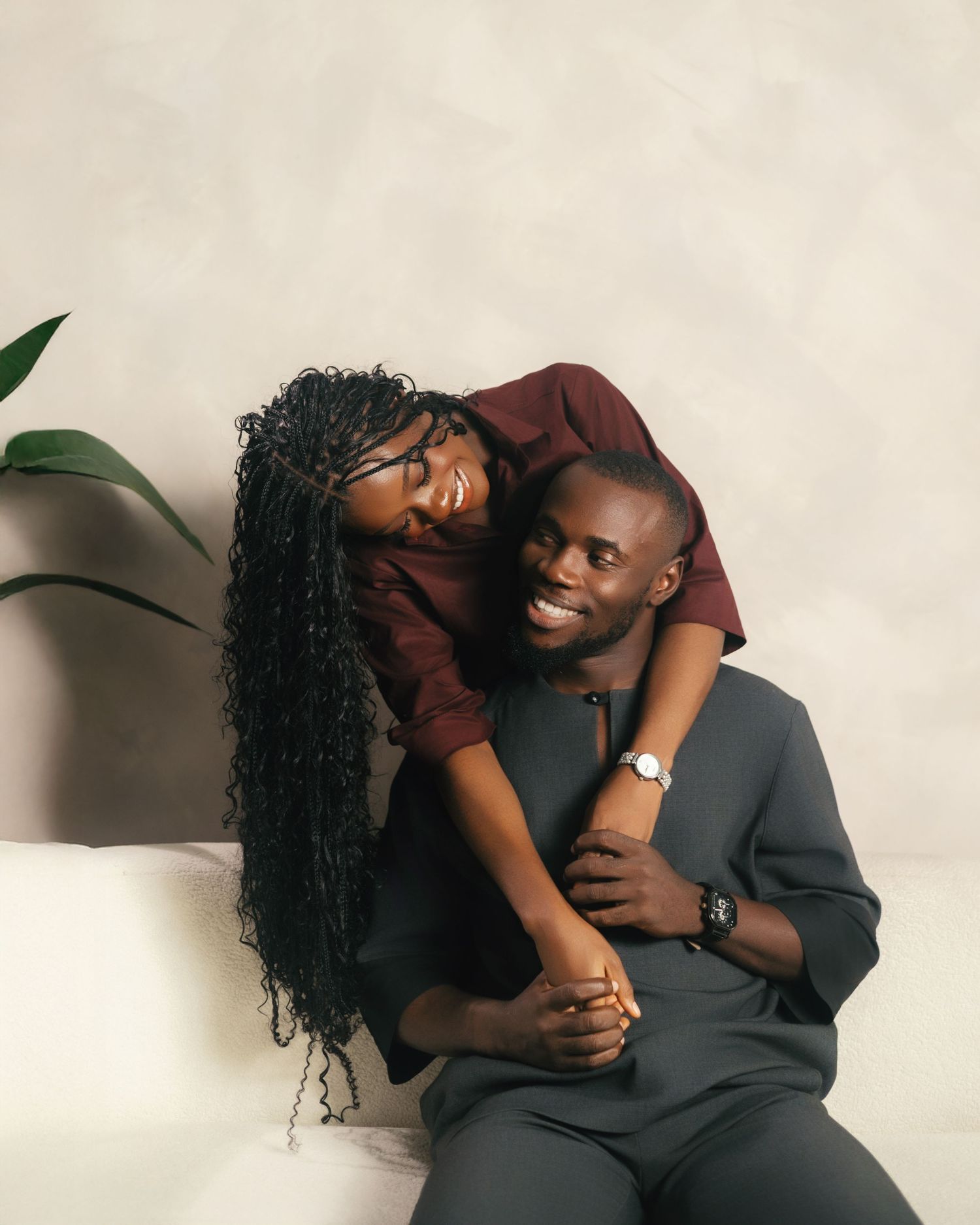 Loving couple shares tender moments during casual photo session on light background.